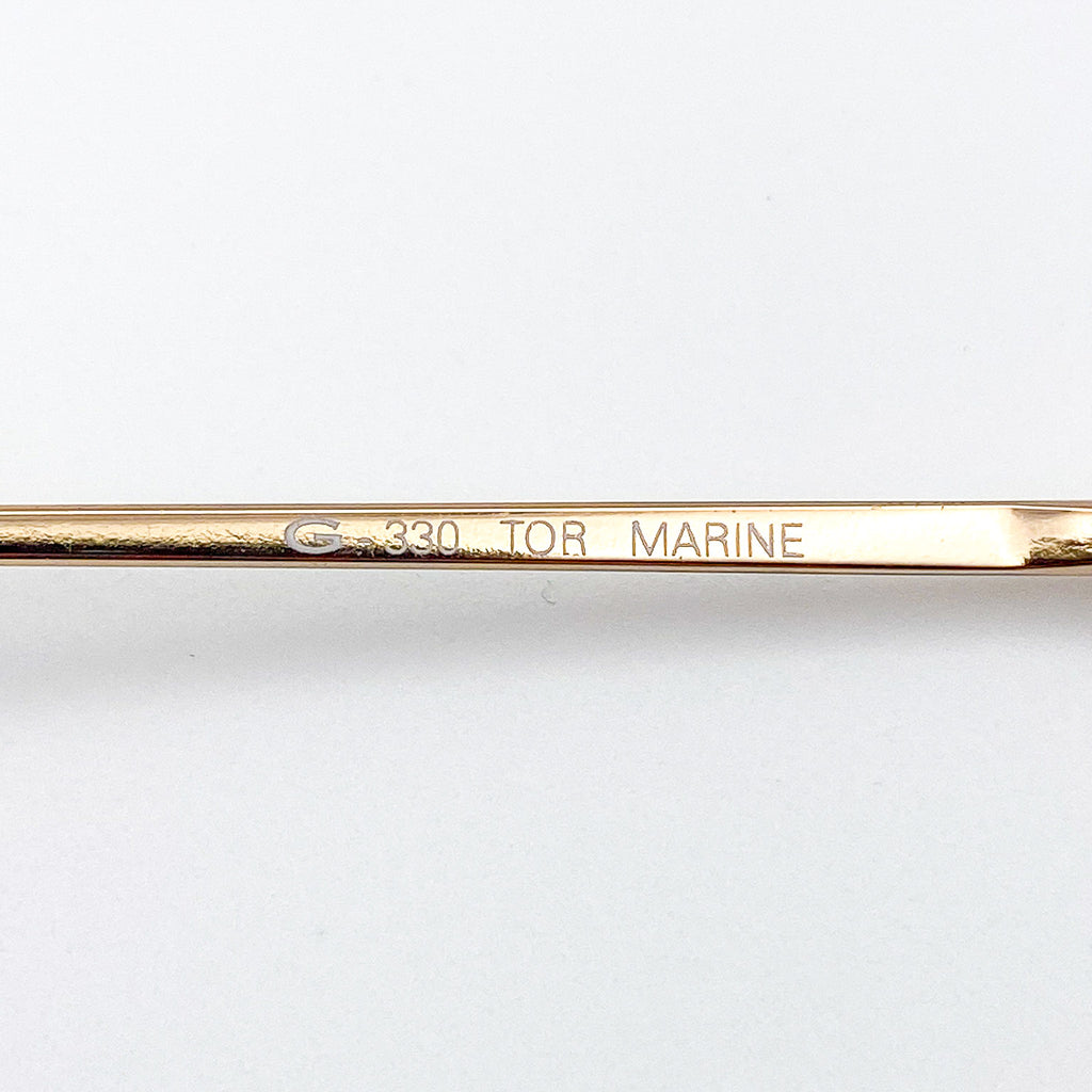 Gold-colored temple with engraved text on a white background