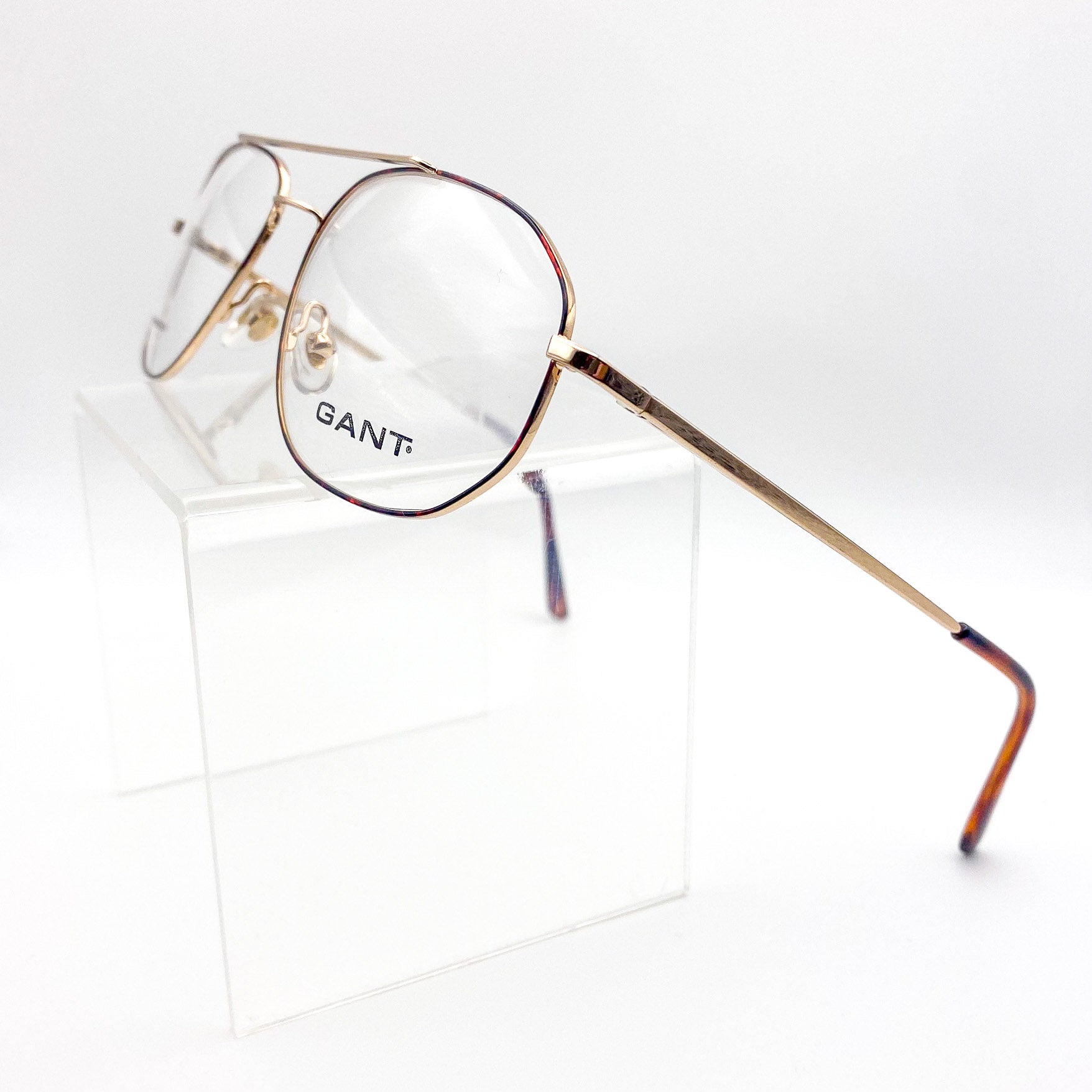 Gold-framed glasses with 'GANT' logo on a white background