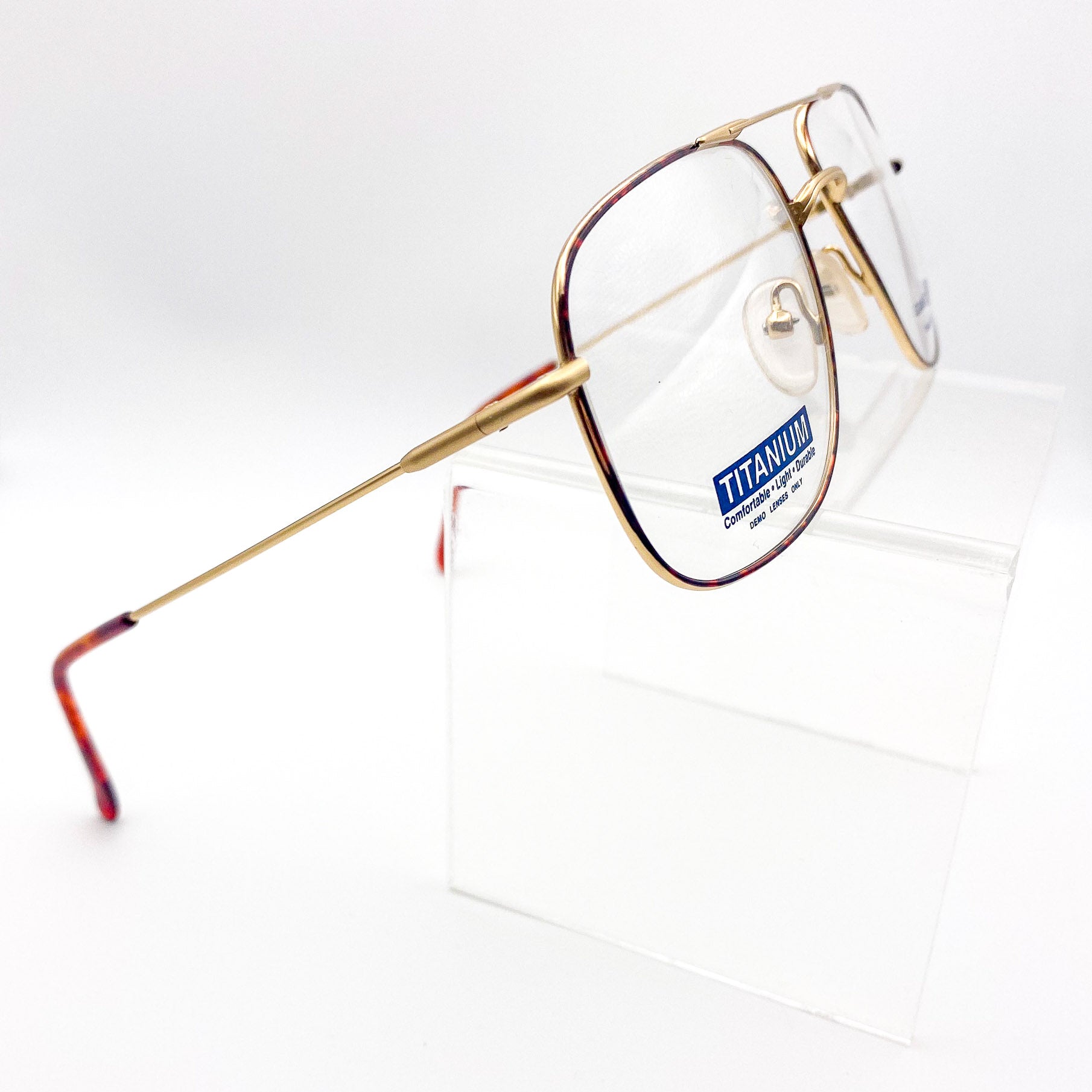 1980s gold-framed eyeglasses with 'Titanium' label on a white background