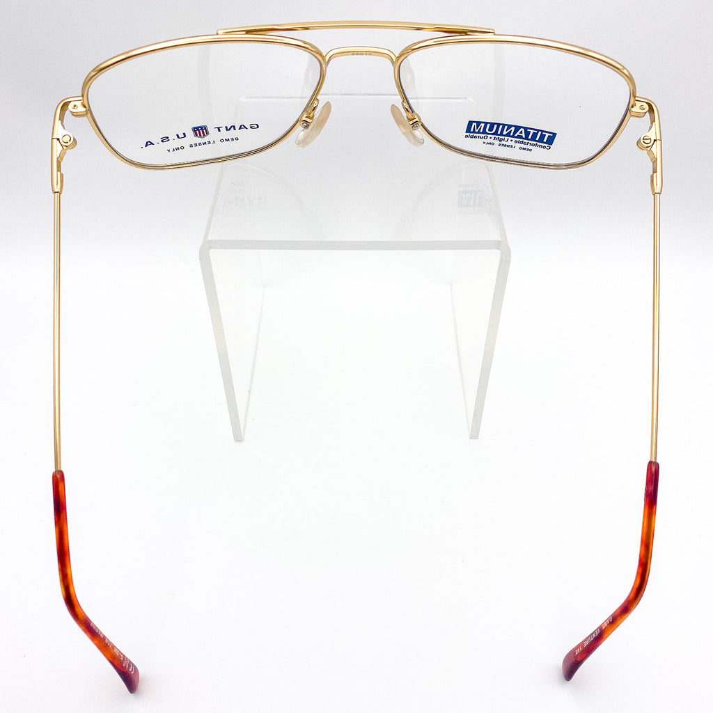 Gold-framed eyeglasses with tortoiseshell arms on a white background