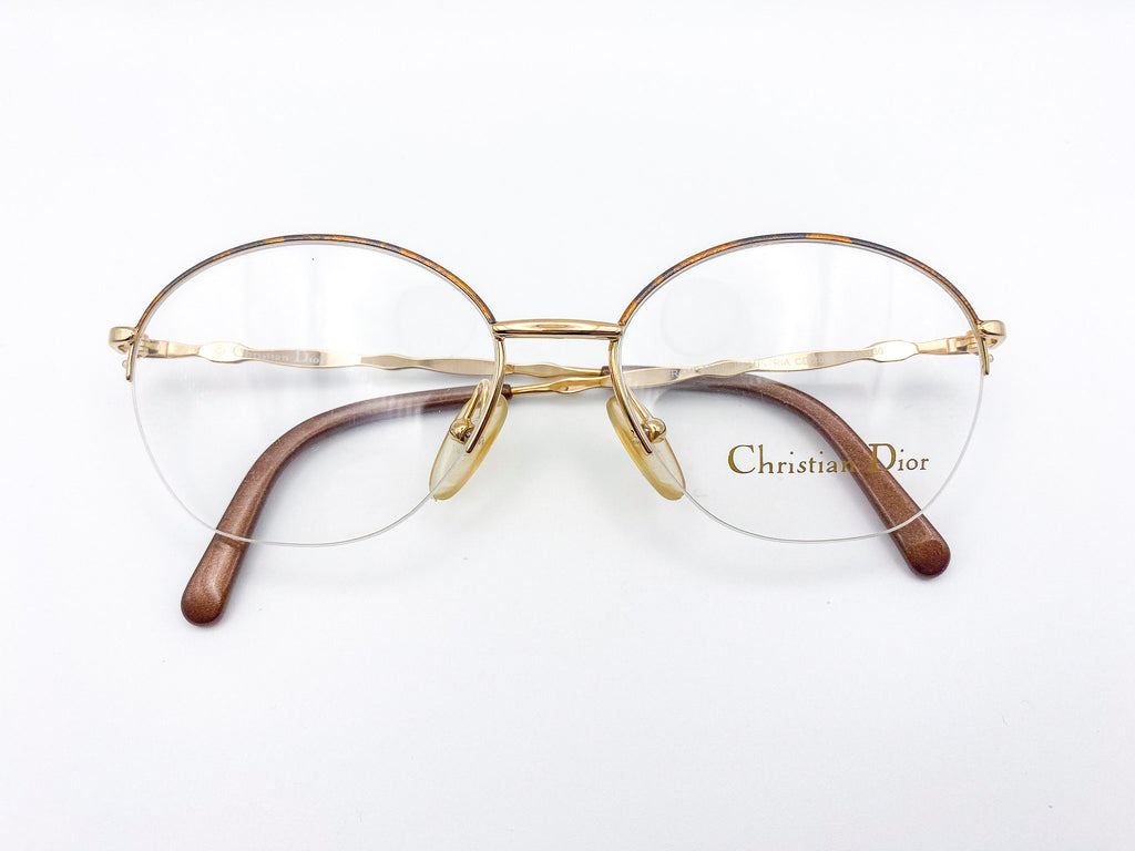 Gold-framed eyeglasses with 'Christian Dior' logo on a white background