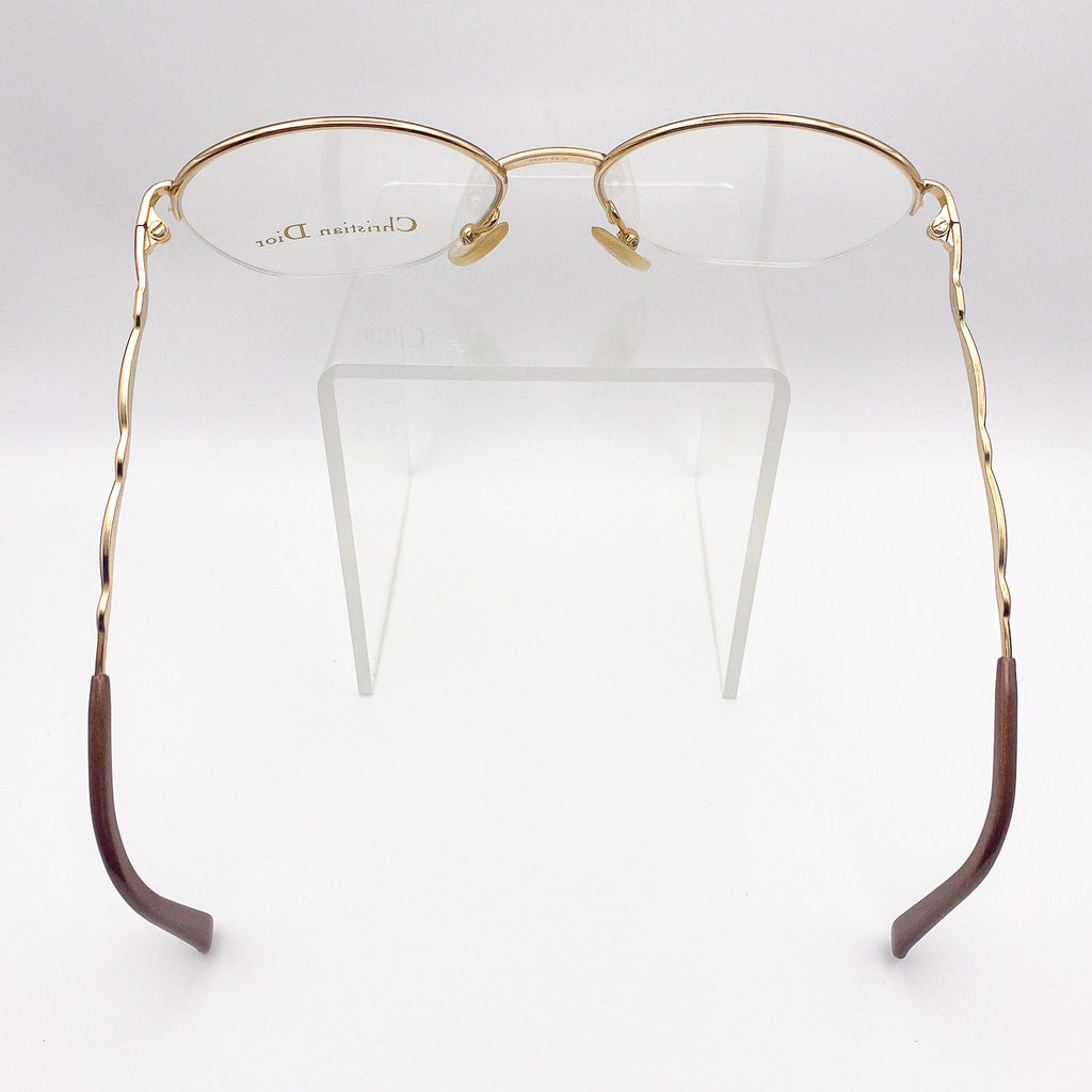 Gold and brown semi-rimless eyeglasses on a white background