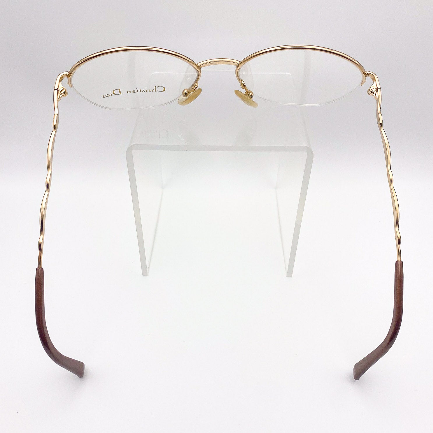 Gold and brown semi-rimless eyeglasses on a white background