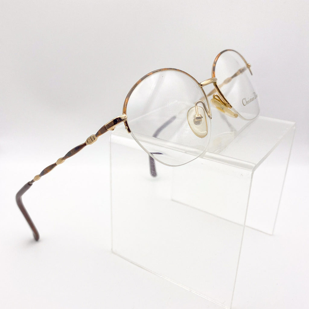 Semi-rimless tortoiseshell and gold eyeglasses on a white background