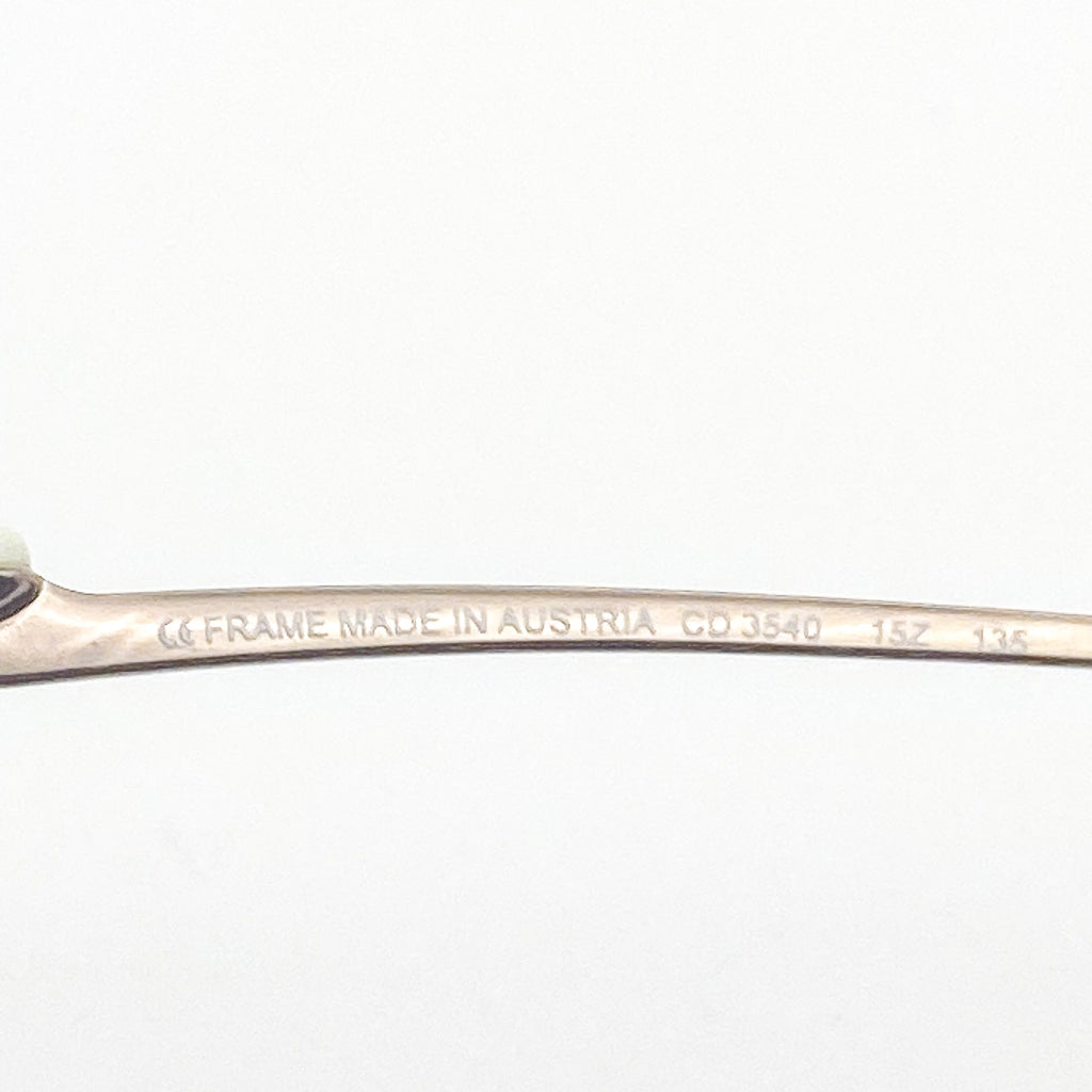 Close-up of a eyeglasses temple frame with 'Made in Austria' engraving on a white background