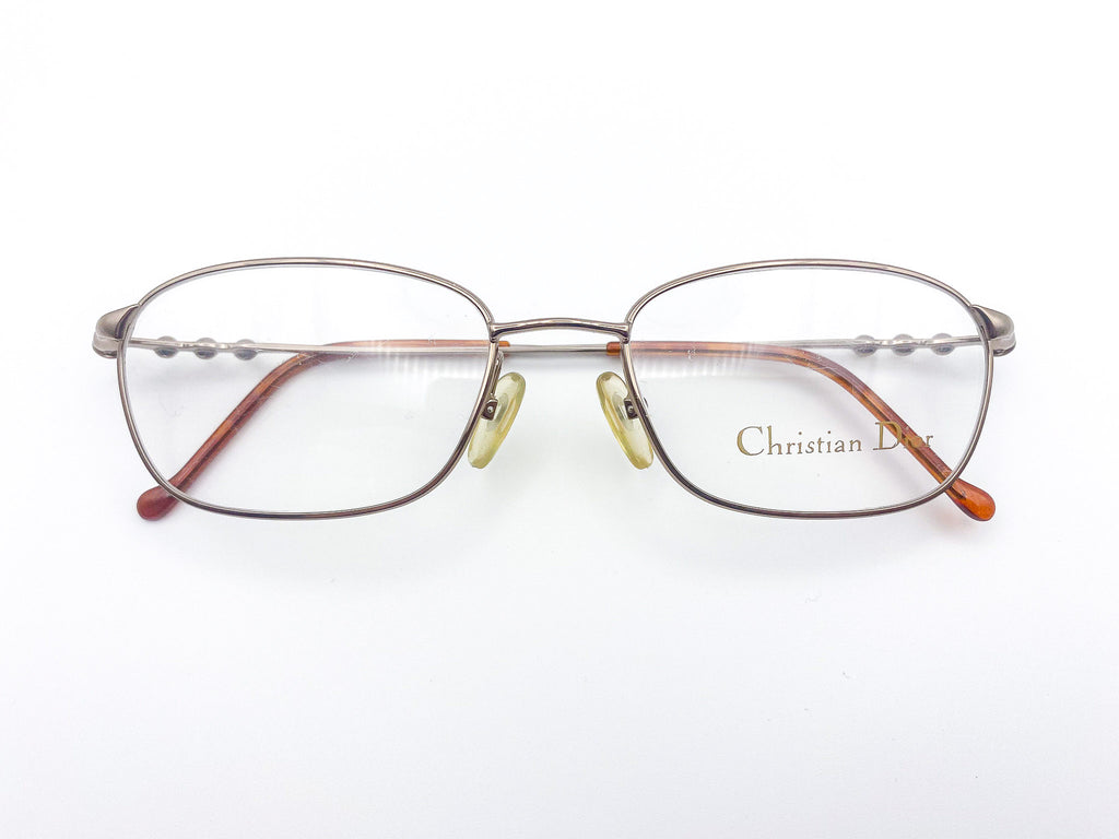 Gunmetal grey eyeglasses with 'Christian Dior' branding on a white background