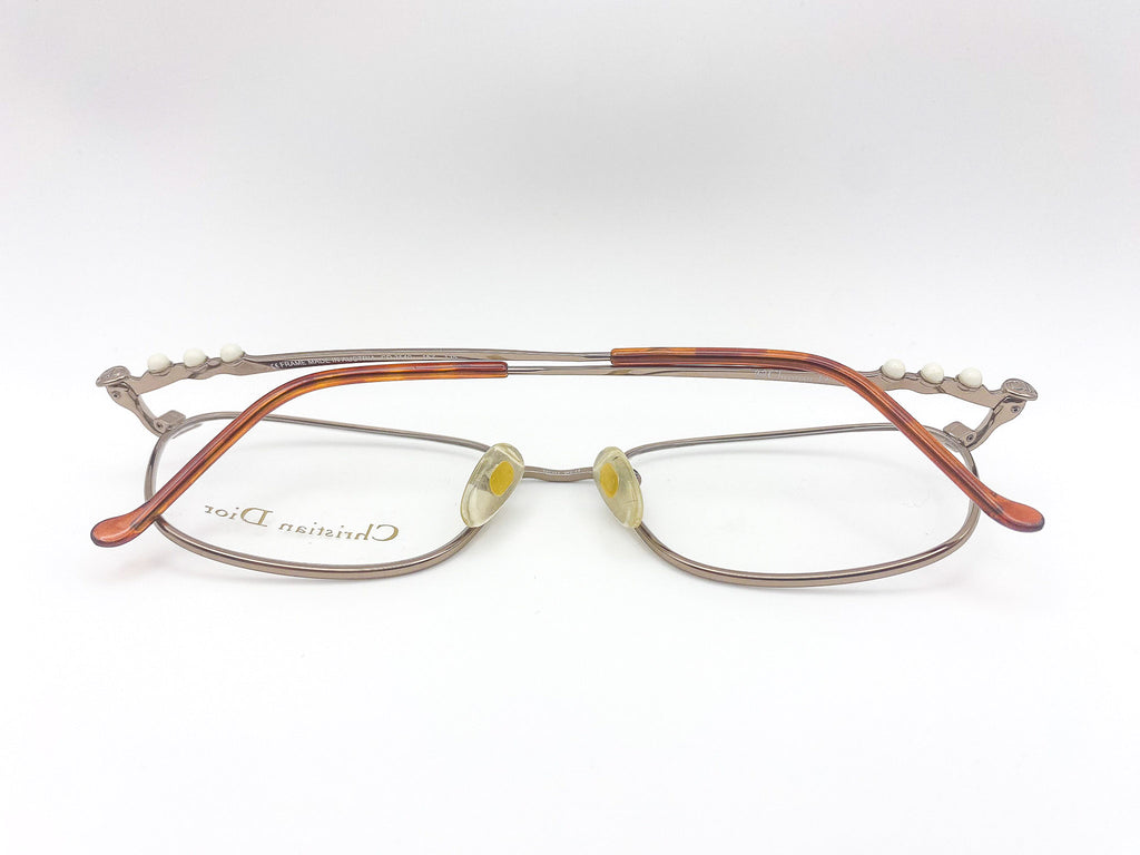 Eyeglasses with a metallic brushed grey frame on a white background