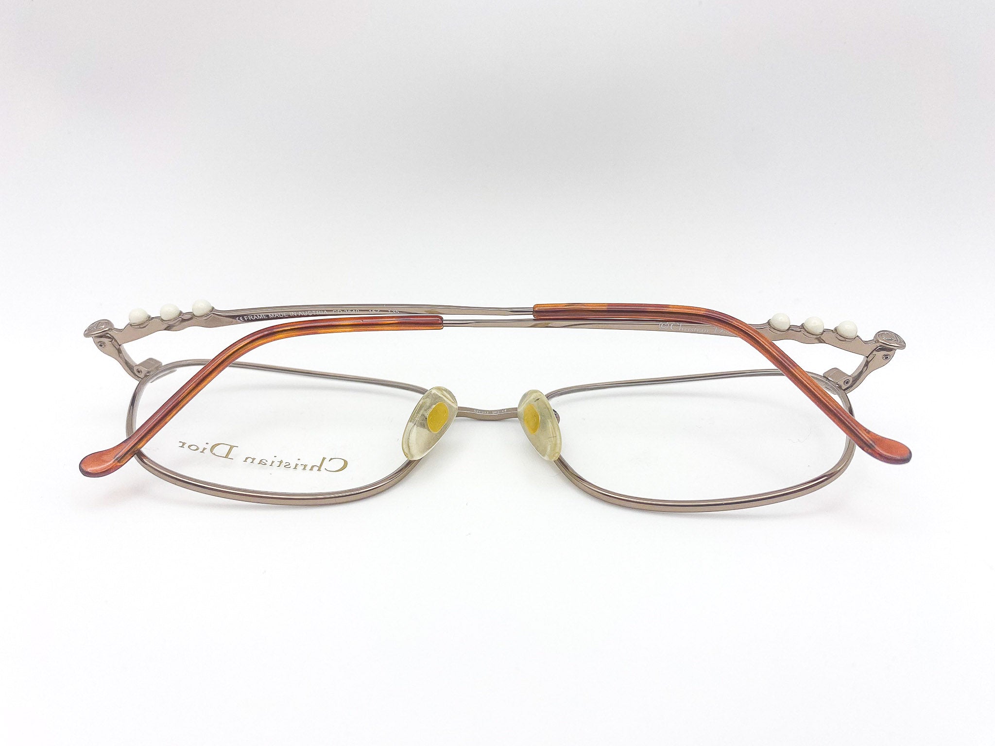 Eyeglasses with a metallic brushed grey frame on a white background