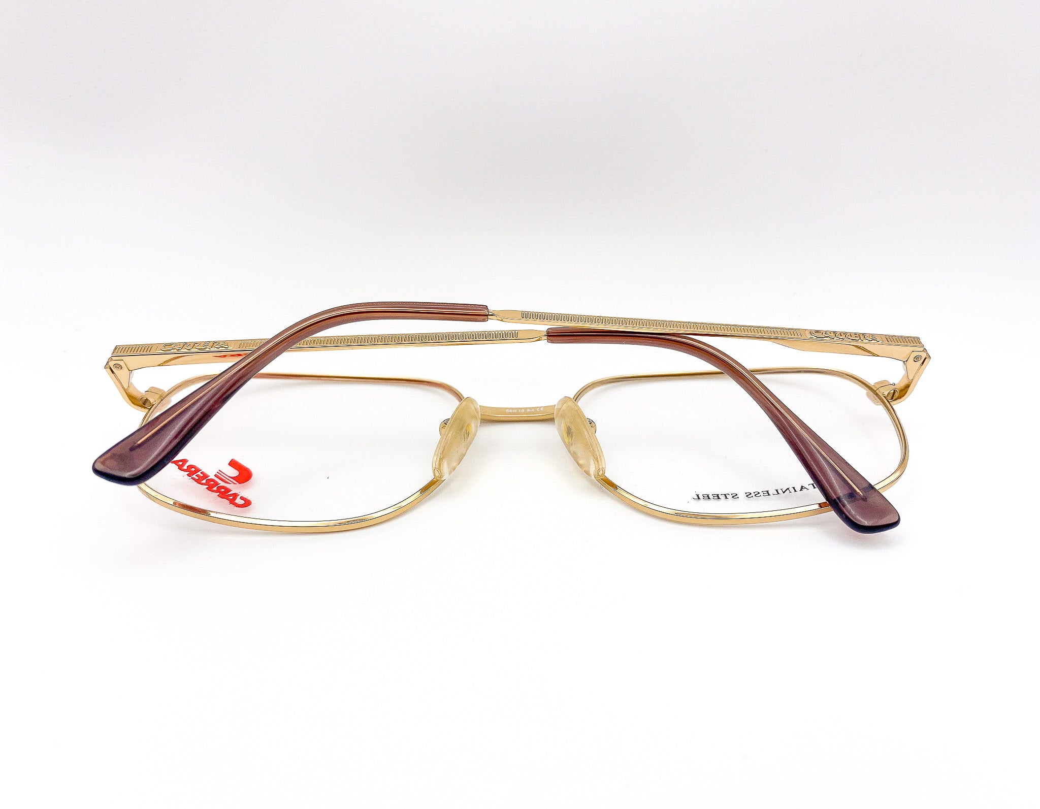 Gold-framed eyeglasses with brown arms on a white background