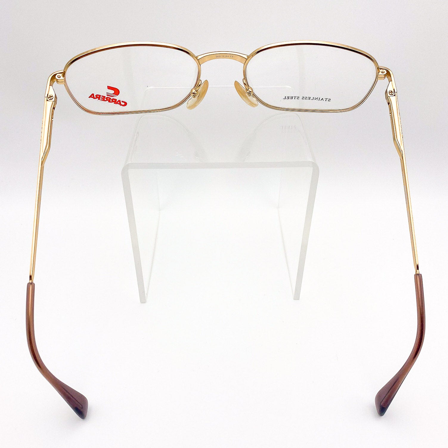 Gold-framed eyeglasses with brown accents on a white background