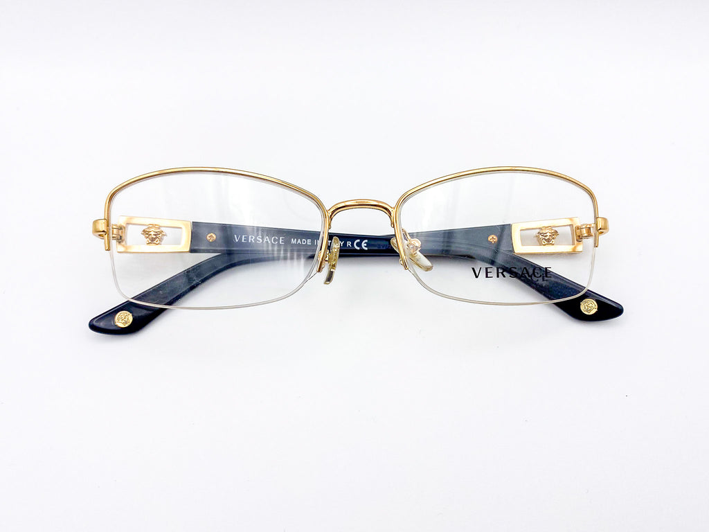 Gold-framed Versace eyeglasses on a white background