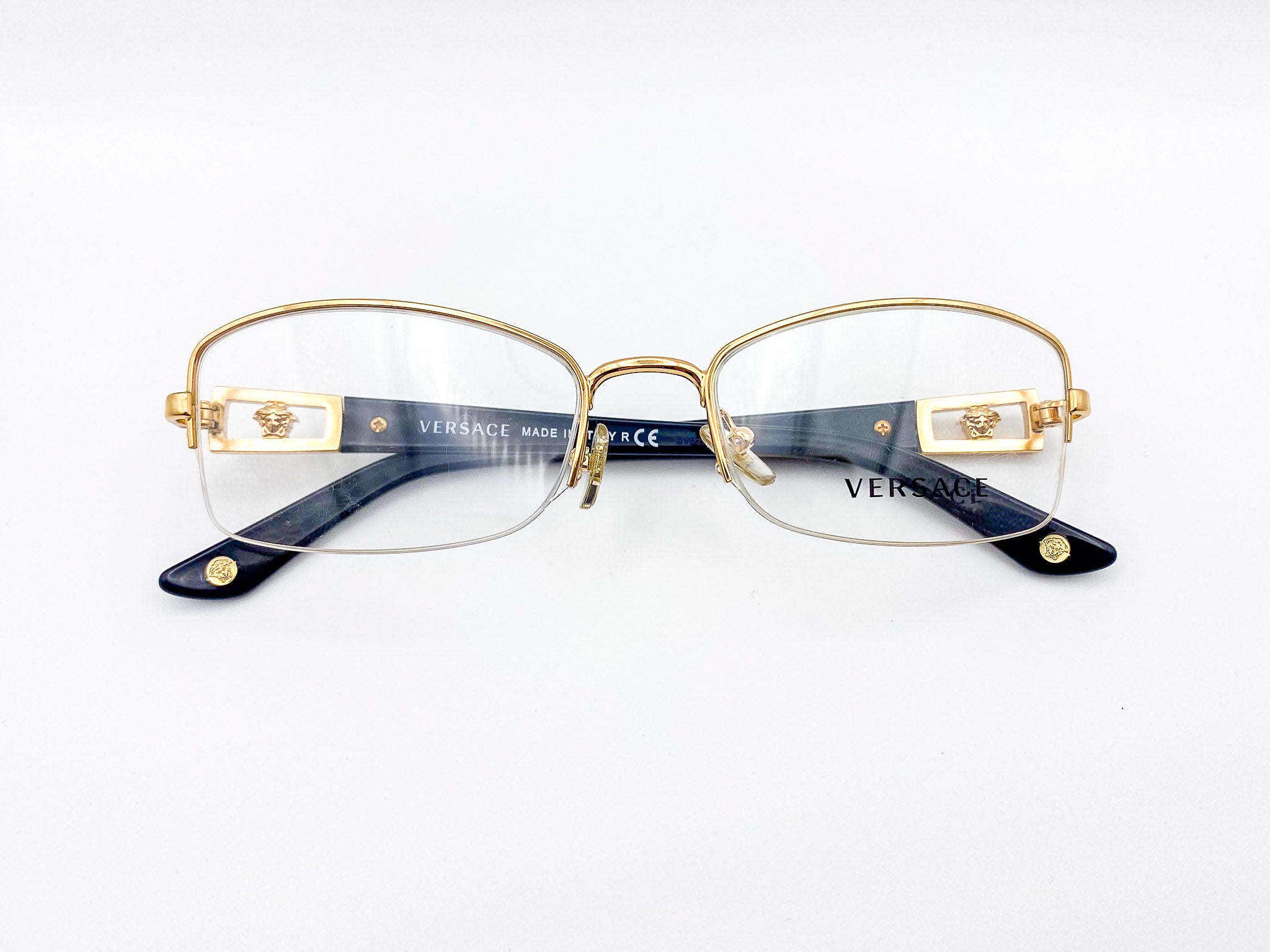 Gold-framed Versace eyeglasses on a white background