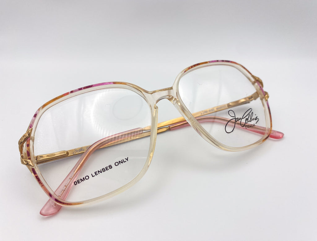 Vintage butterfly glasses with gold frame and pink accents on a white background
