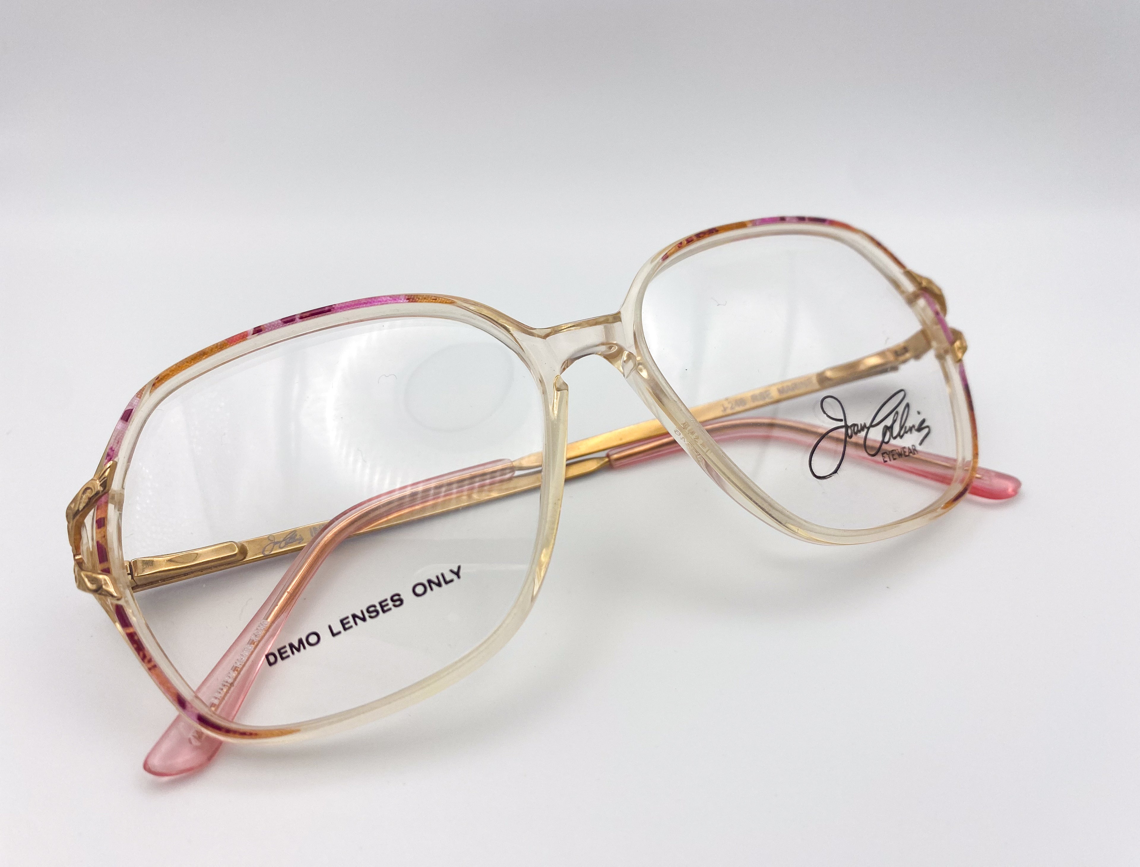 Vintage butterfly glasses with gold frame and pink accents on a white background