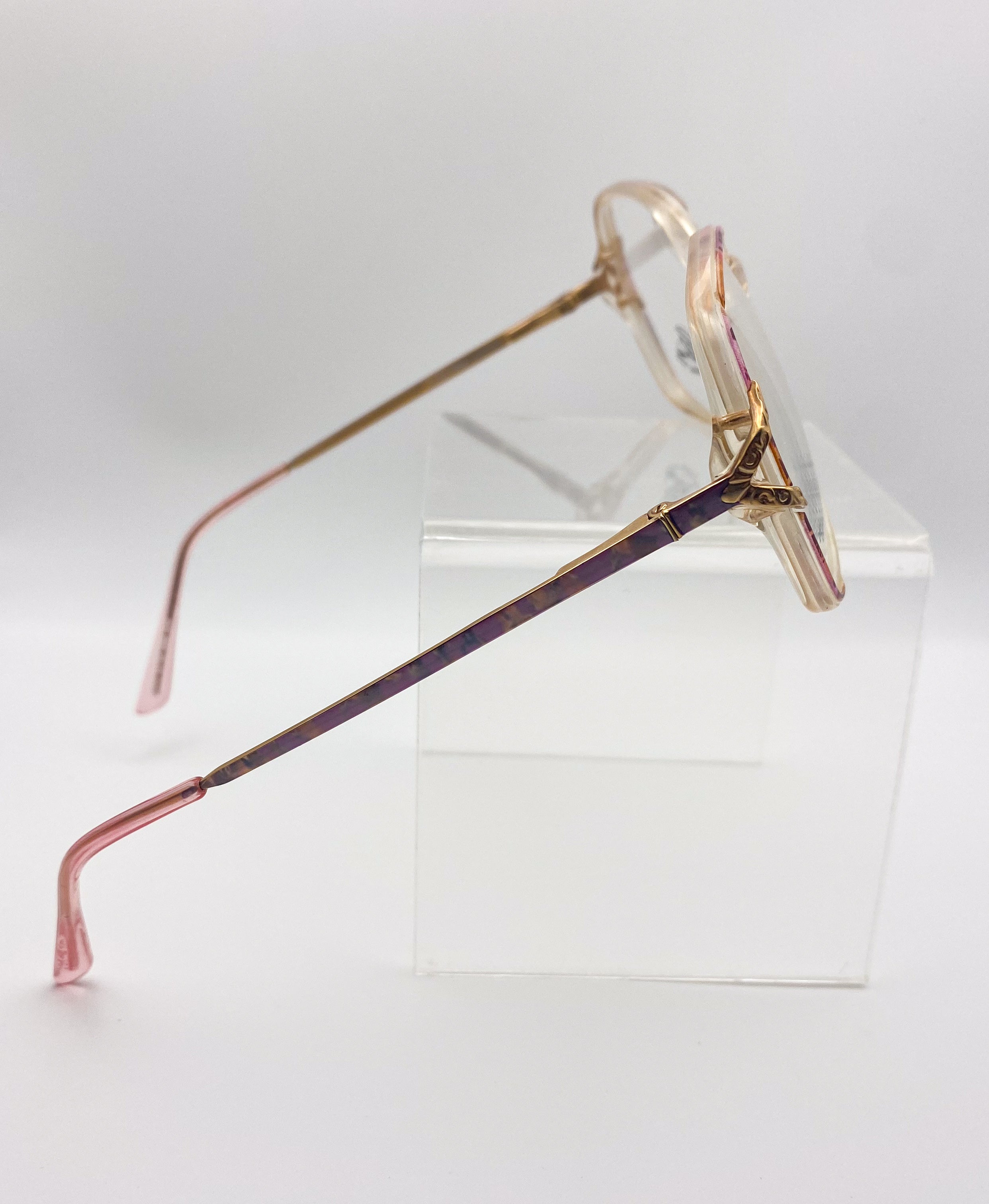 Eyeglasses with a unique frame design on a clear stand against a white background
