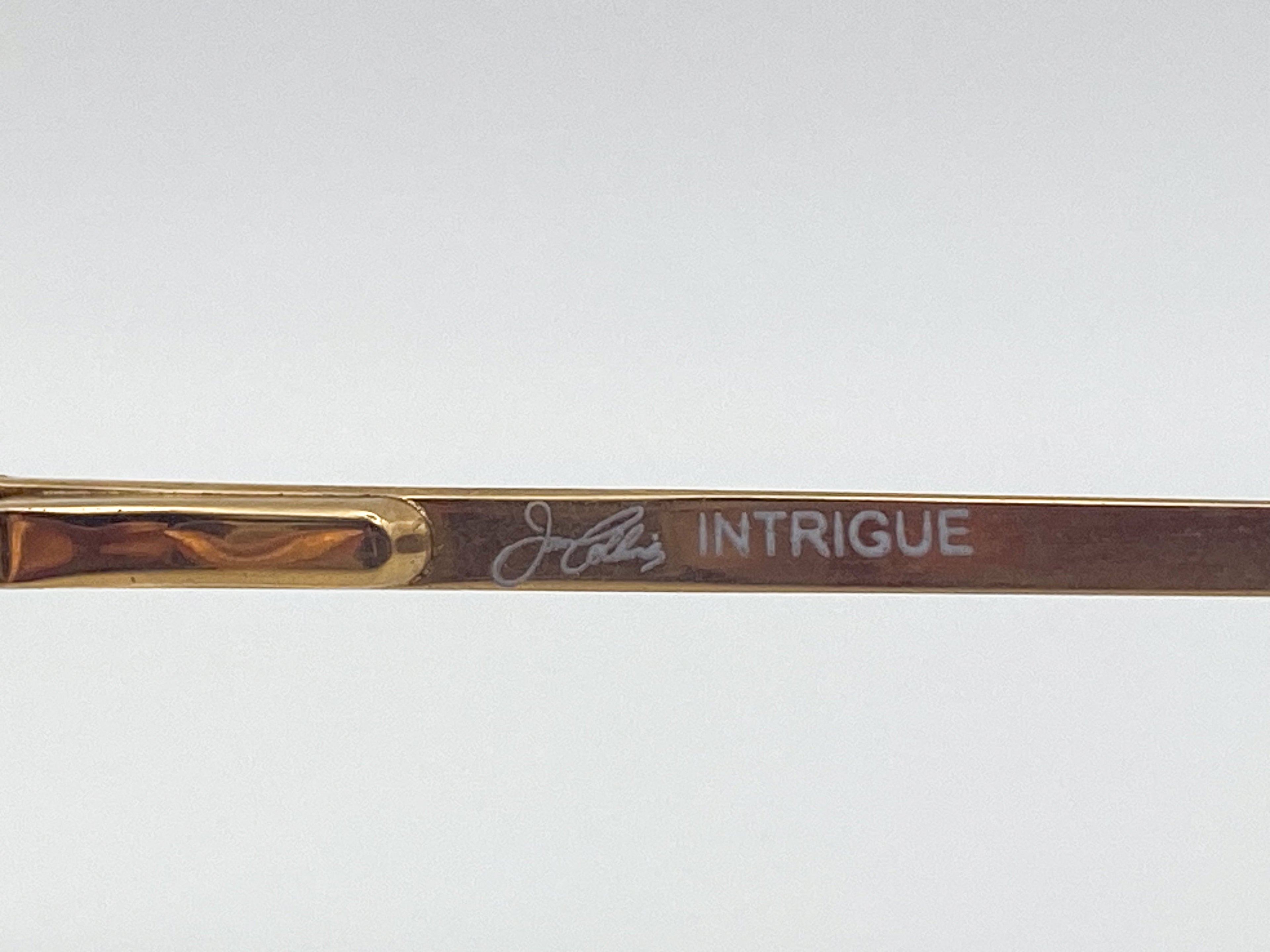 Gold eyeglasses temple arm with 'Intrigue' branding on a white background