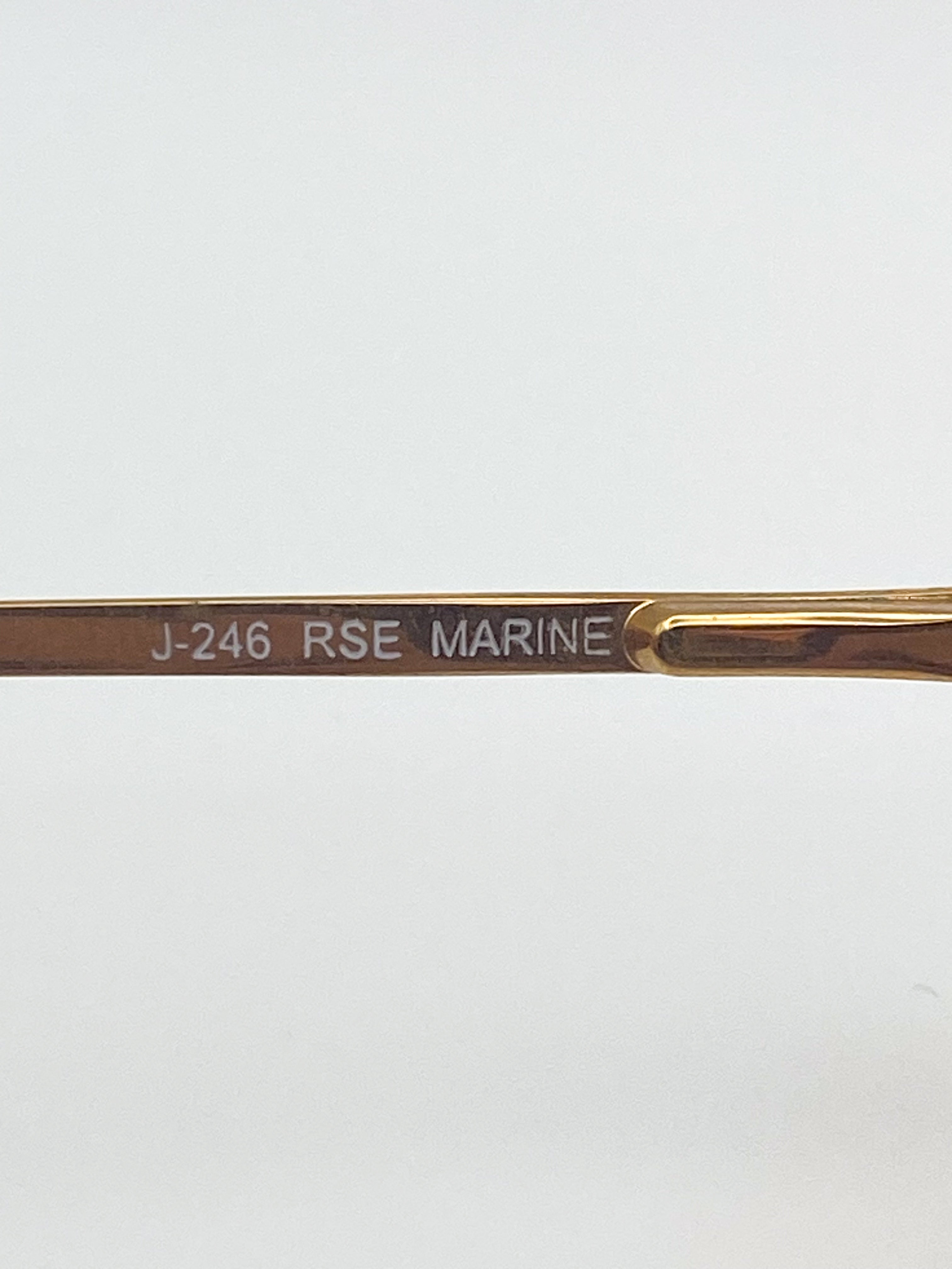 Gold glasses arm with 'J-246 RSE MARINE' engraving on a white background