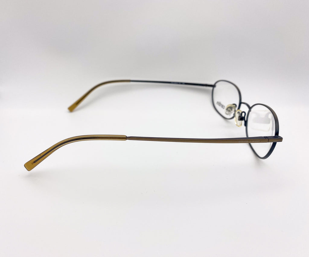 Pair of 1990s eyeglasses with gold frame and black arms on a white background