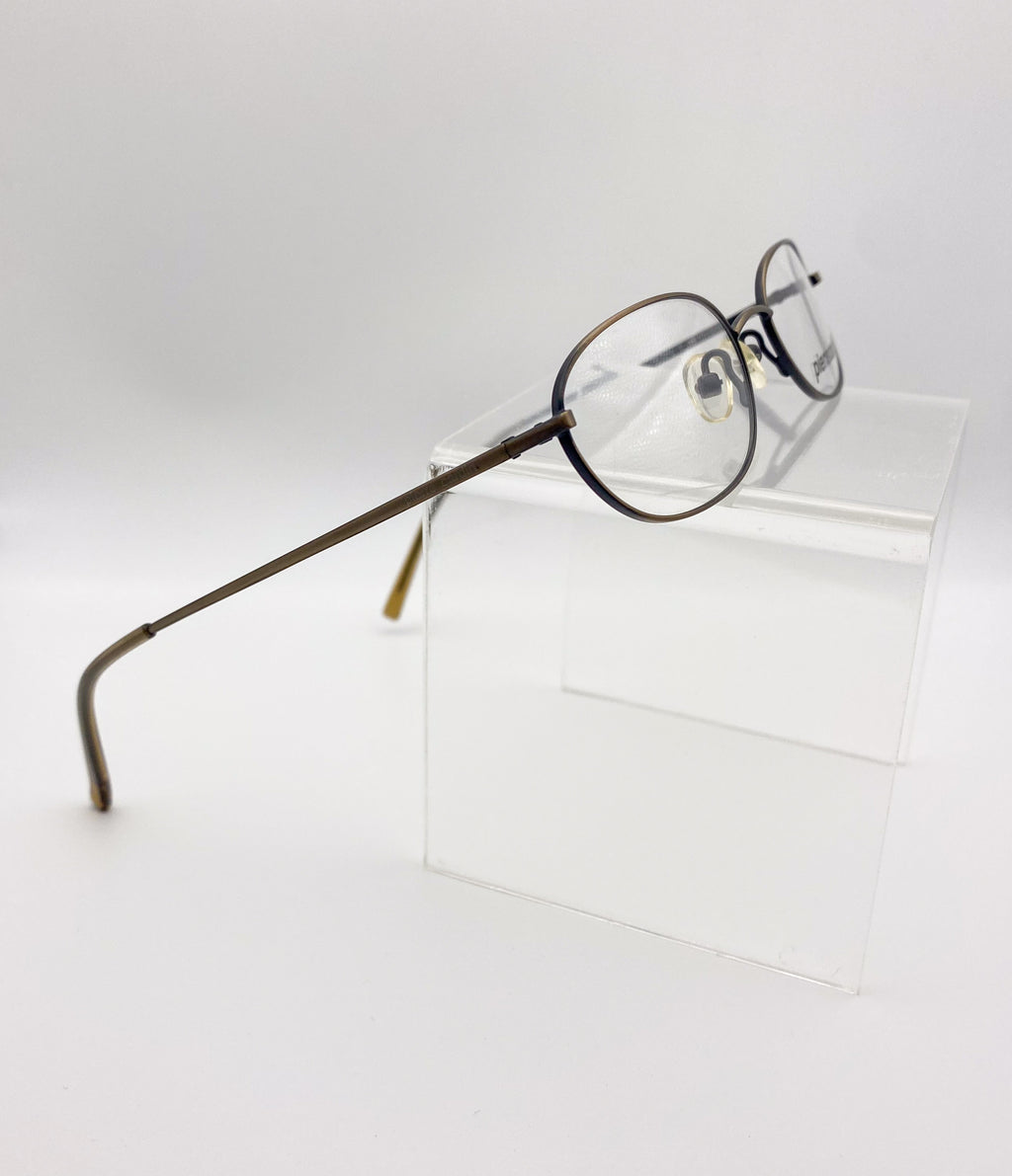 1990s eyeglasses on a clear stand against a white background