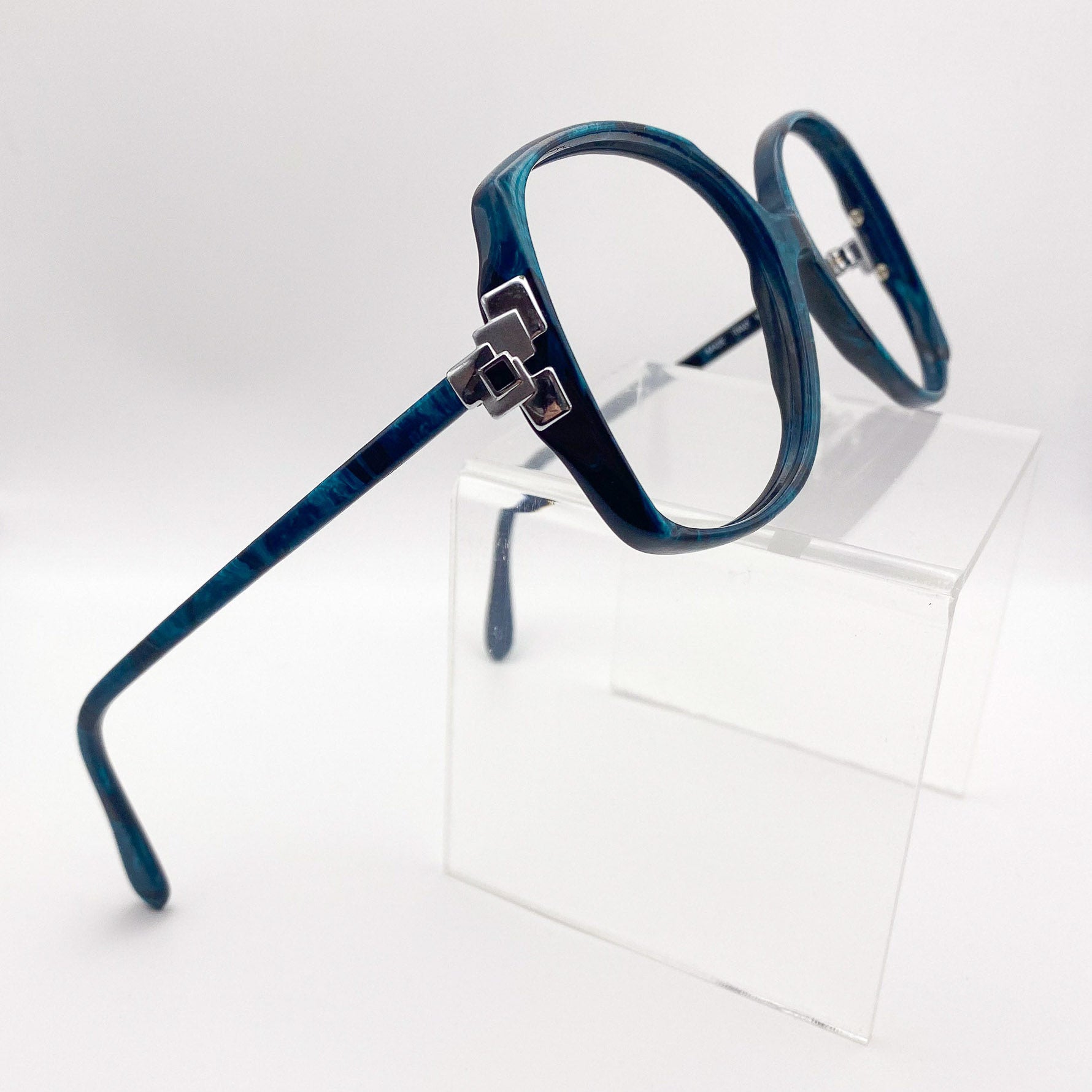 Black and turquoise eyeglasses with a silver temple piece on a white background