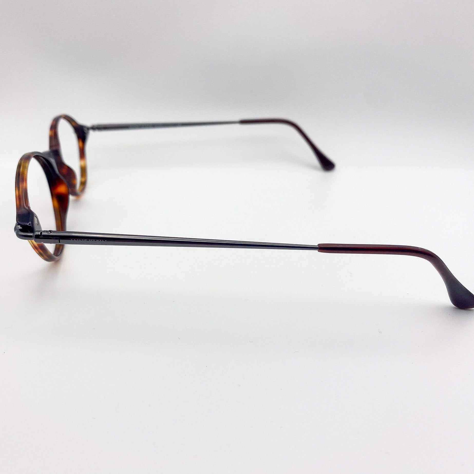Eyeglasses with tortoiseshell accents on a light gray background