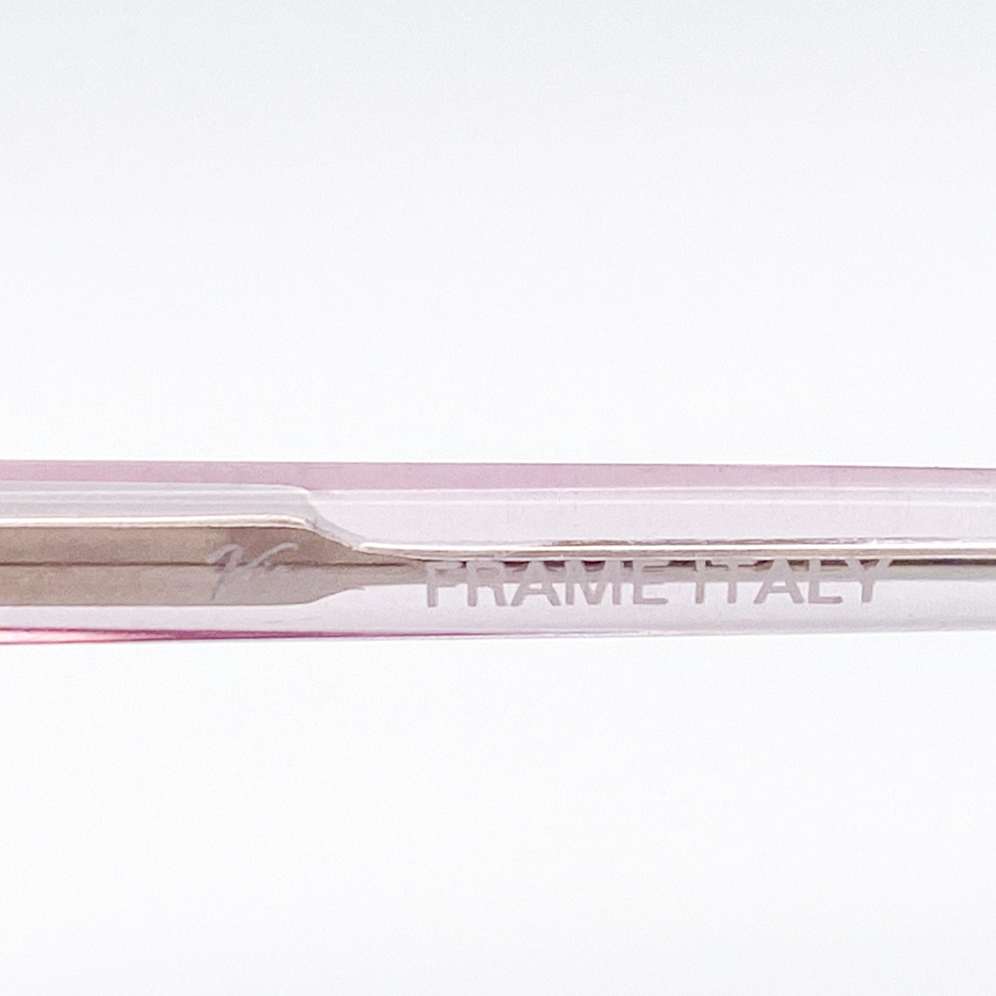 Close-up of a pink and silver temple stem with 'FRAME ITALY' branding on a white background.