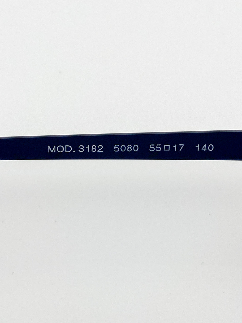 Close-up of a black eyeglass frame with model and size details on a white background