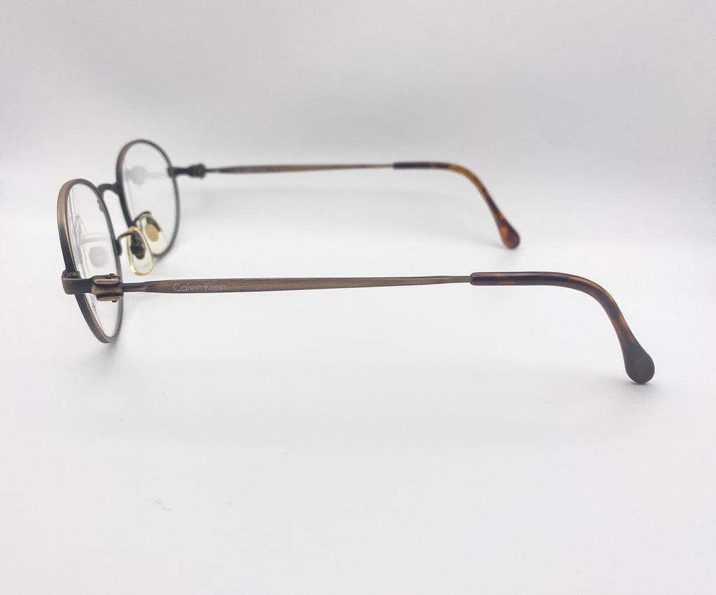 Pair of metal eyeglasses on a light gray background