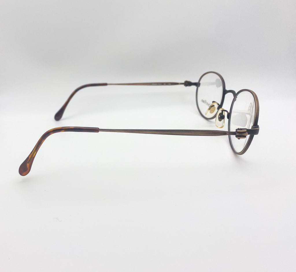 Round eyeglasses with tortoiseshell frame on a light gray background