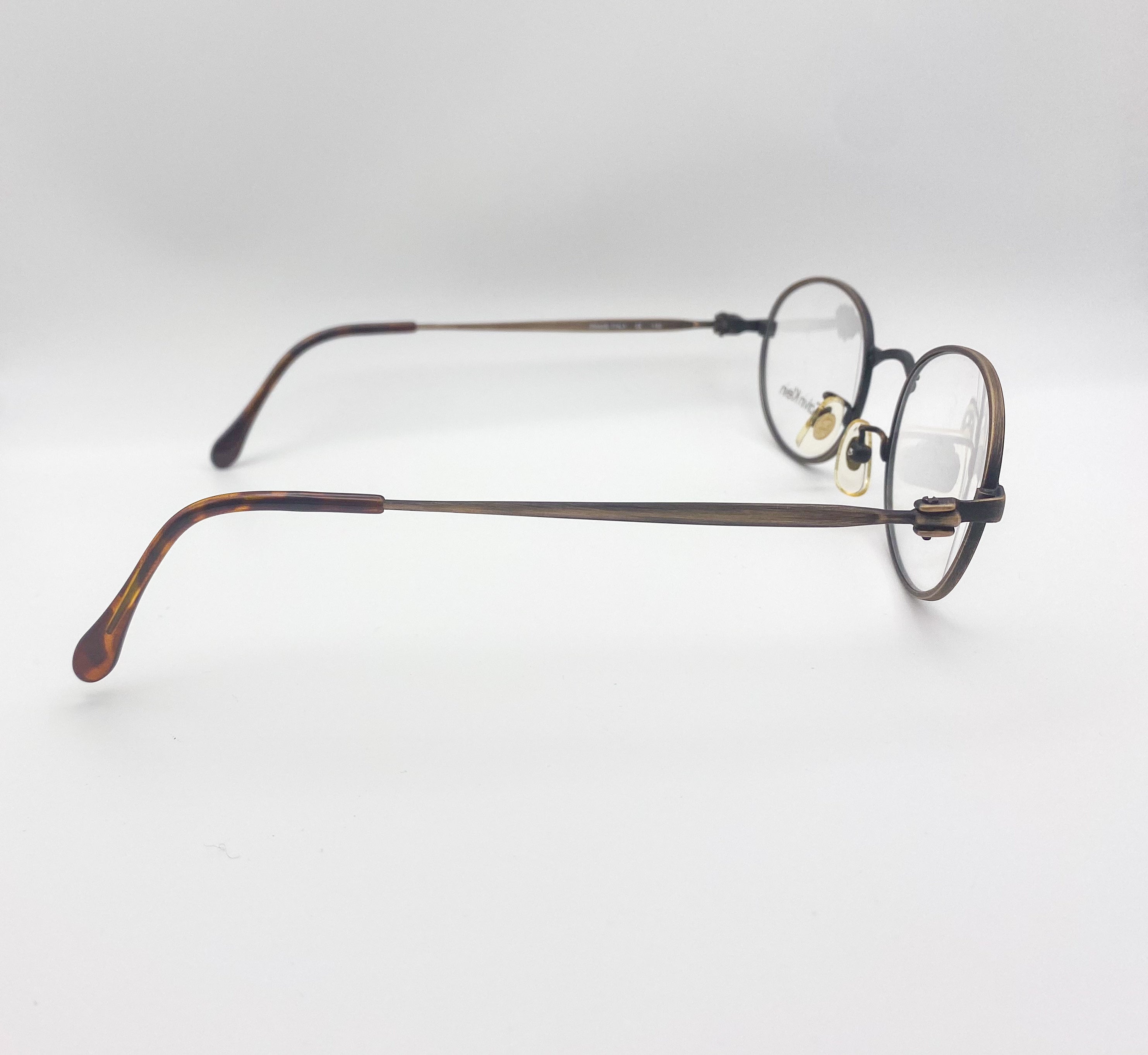 Round eyeglasses with tortoiseshell frame on a light gray background