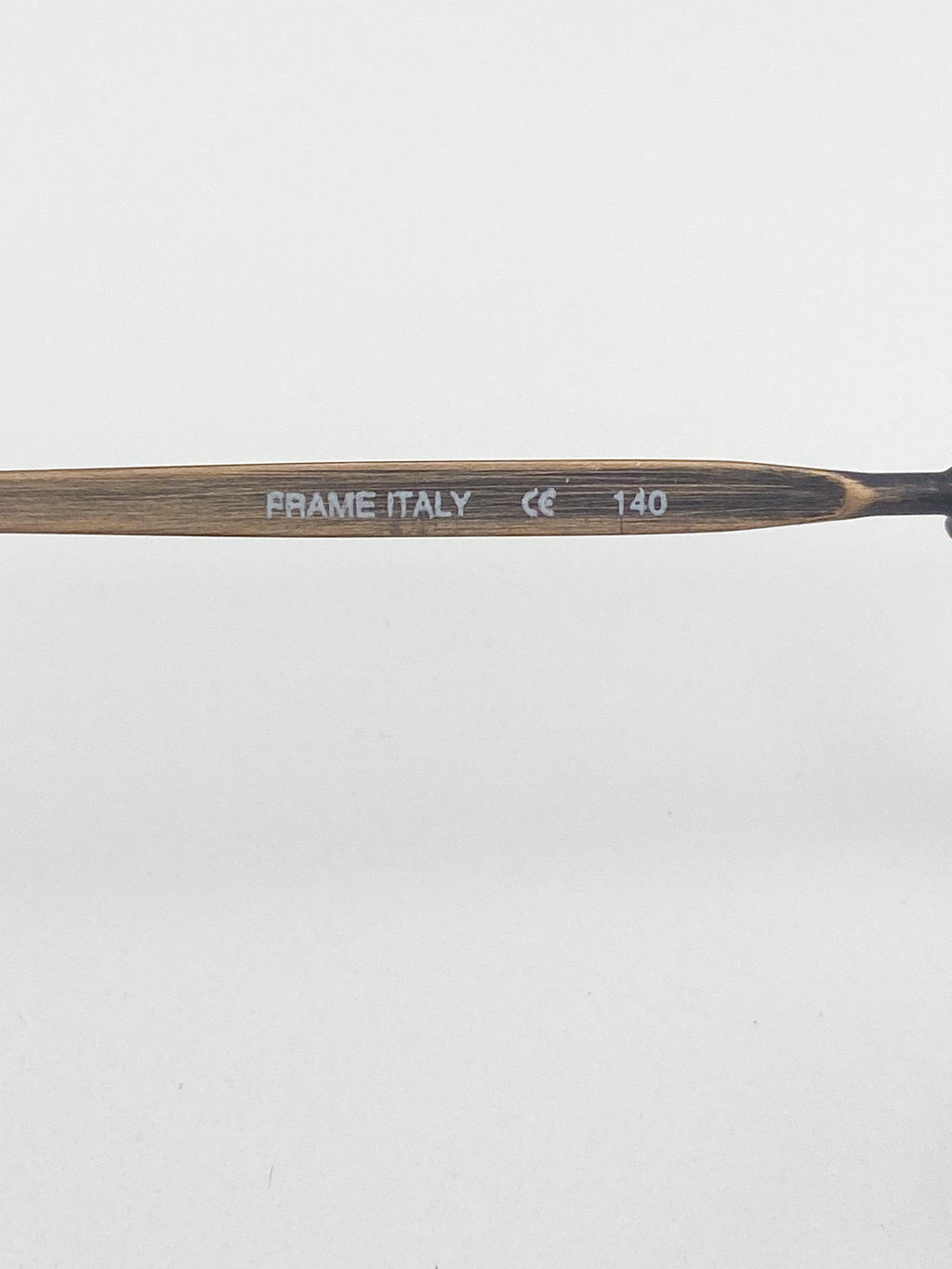 Eyeglasses stem with 'FRAME ITALY' branding on a white background
