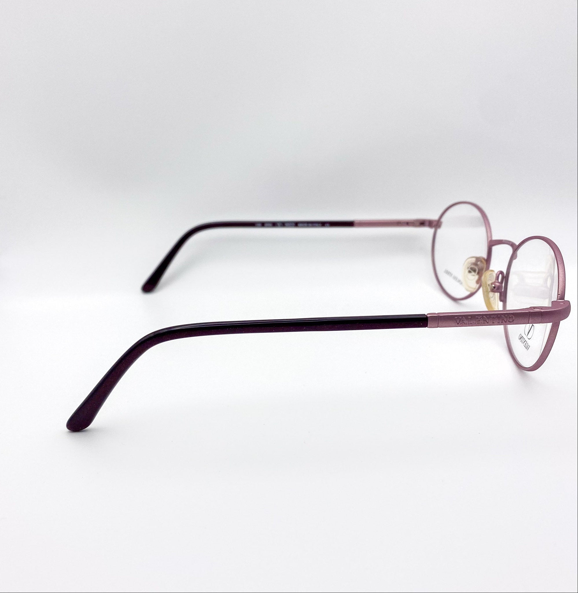 Eyeglasses with a lavender and black frame on a white background