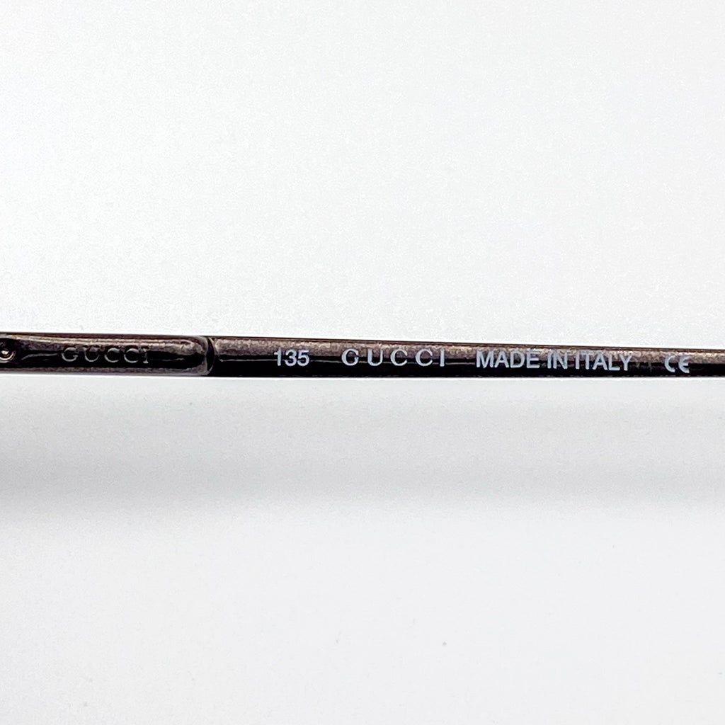 Gucci eyeglasses temple with brand name and 'Made in Italy' text on a white background