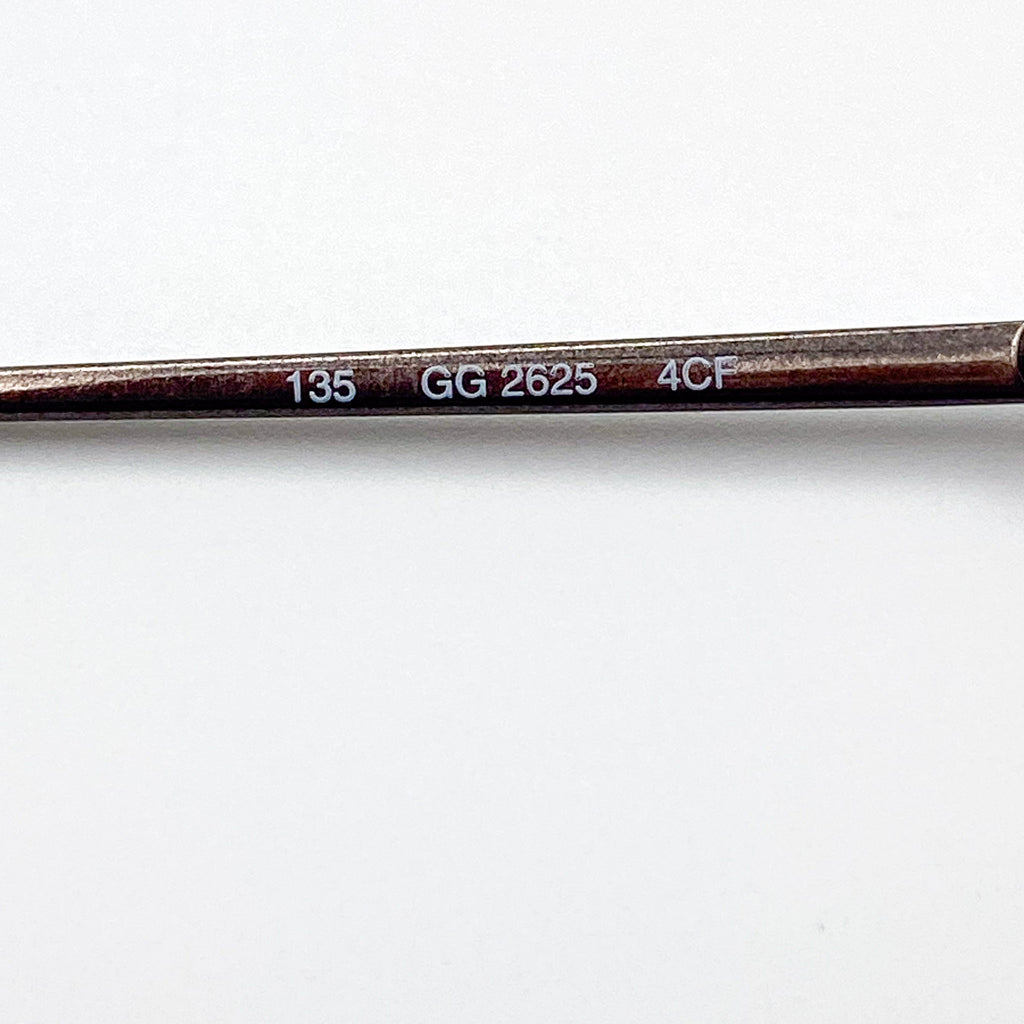 Close-up of an eyeglasses temple stem with engraved text on a white background