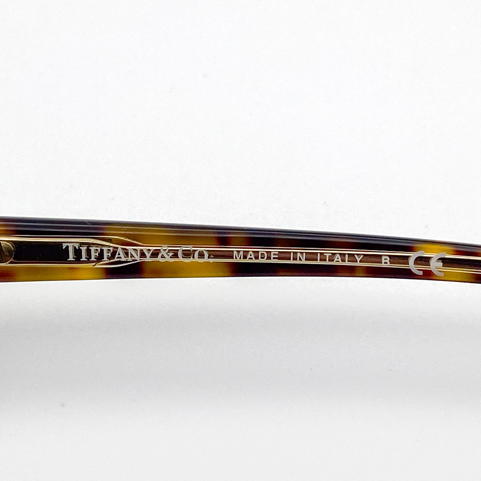 Tortoiseshell eyeglass frame with 'Tiffany & Co. Made in Italy' engraving on a white background