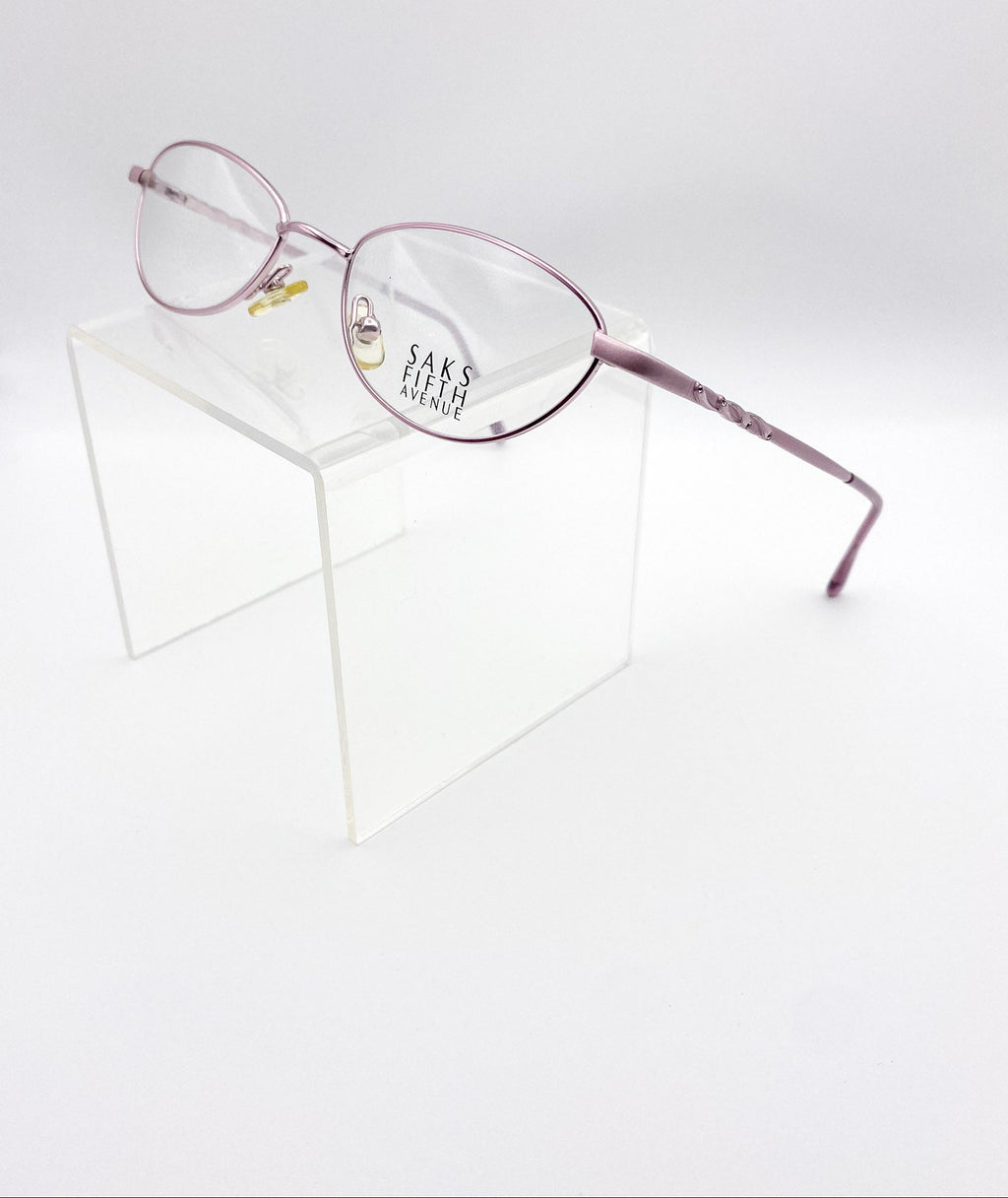 Lavender eyeglasses on a white background with 'Saks Fifth Avenue' branding.