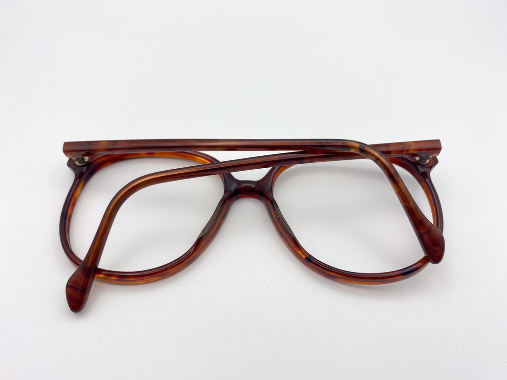 1980s Luxottica tortoiseshell eyeglasses on a white background