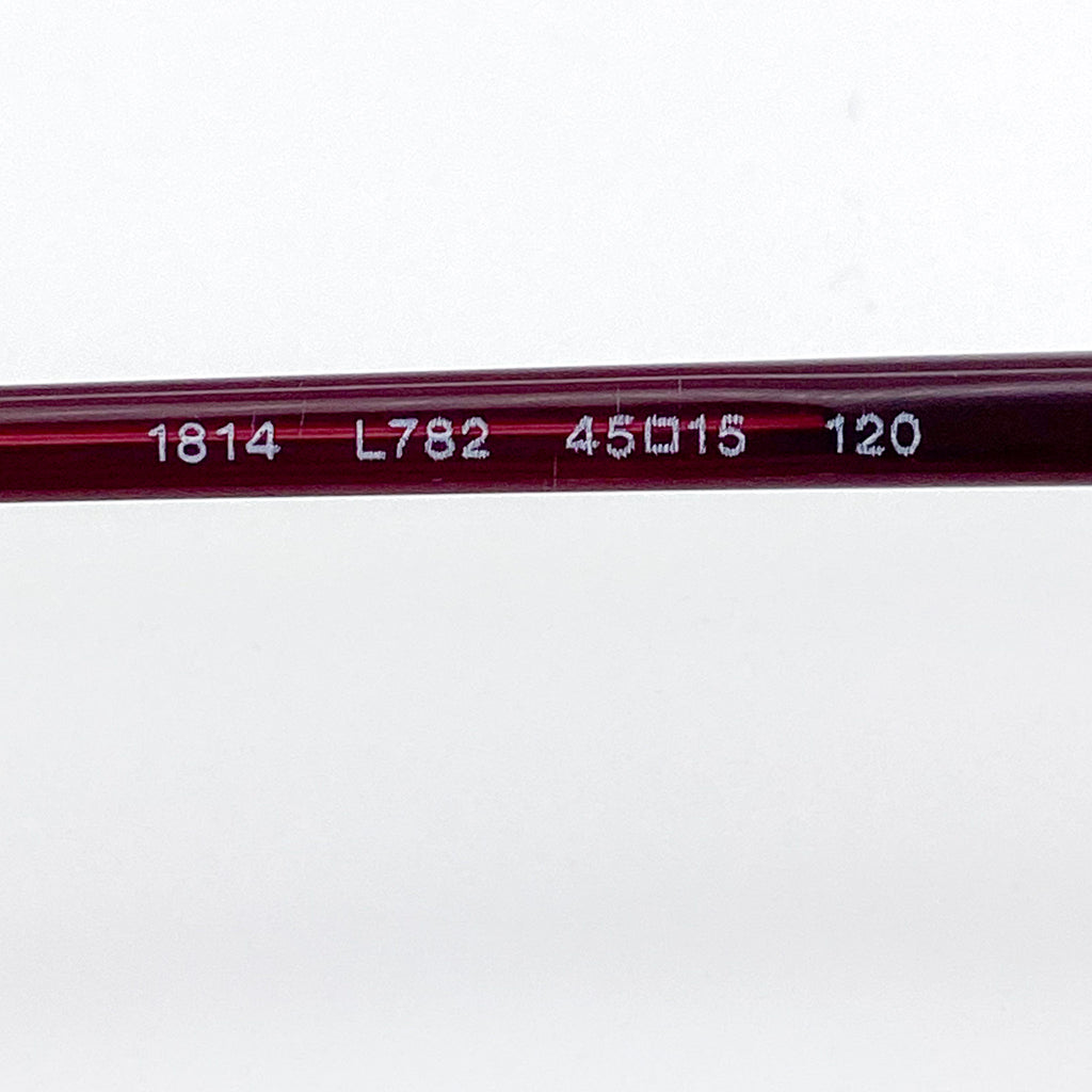 Close-up of a red eyeglass stem with engraved numbers on a white background