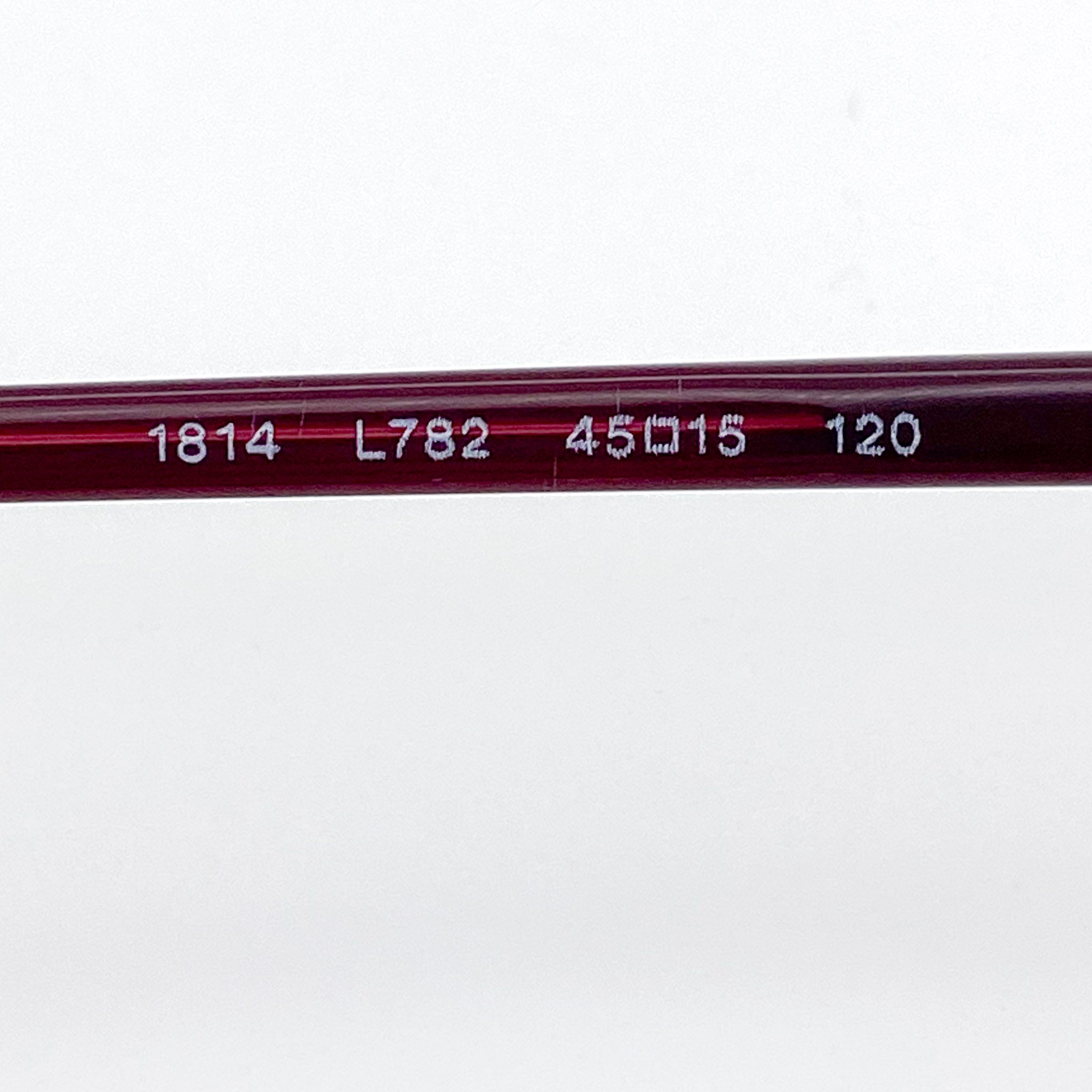 Close-up of a red eyeglass stem with engraved numbers on a white background