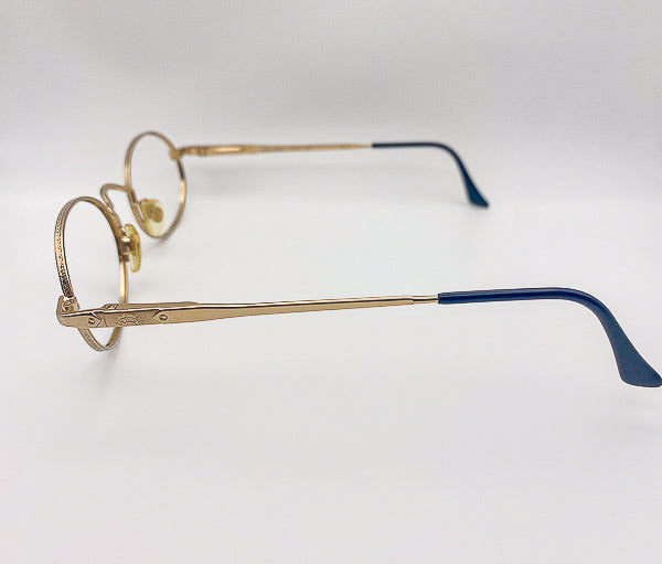 Gold-rimmed eyeglasses with black tips on a white background