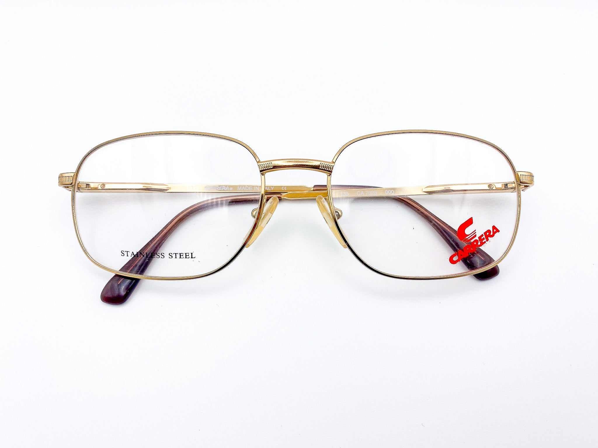 Vintage gold-framed eyeglasses with a visible Carrera brand logo on a white background