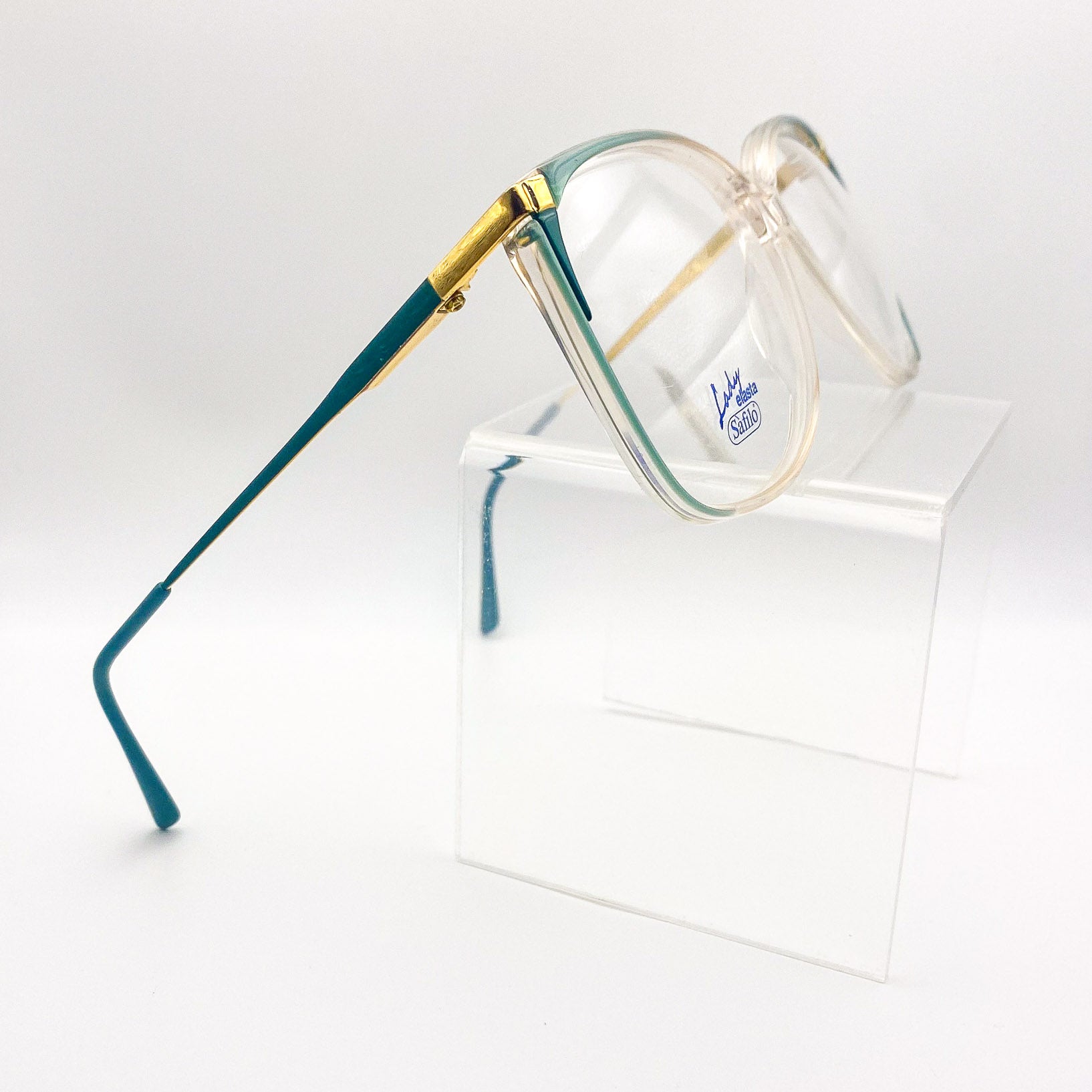 Oversized eyeglasses with teal and gold frame on a white background