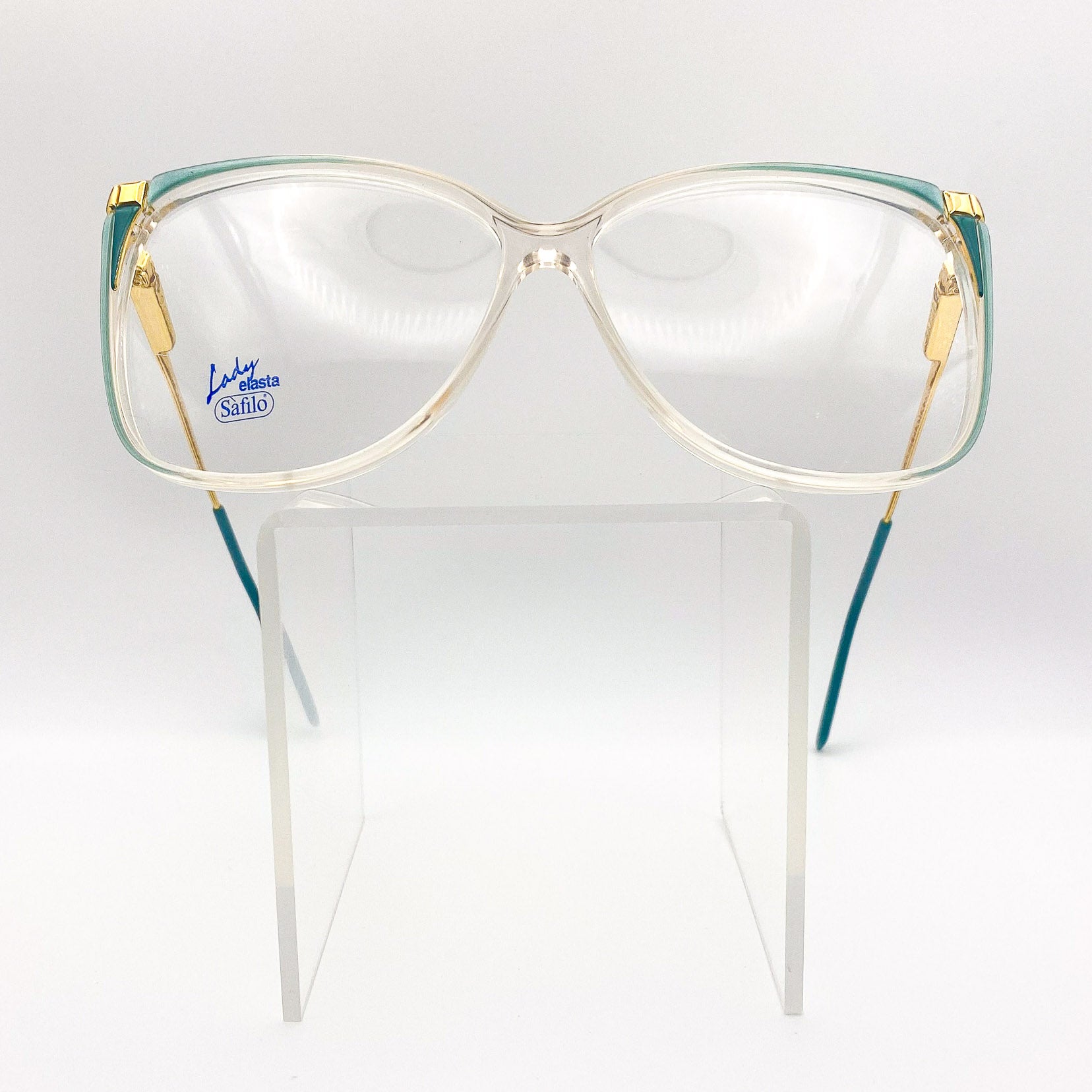 Vintage Safilo eyeglasses with gold and green frame on a white background