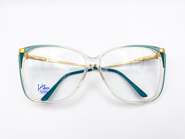 Oversized butterfly glasses with gold and teal frame on a white background