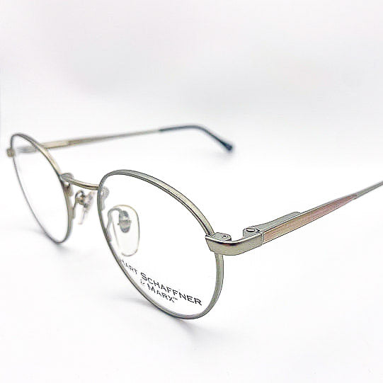 Vintage silver eyeglasses with branding on a white background