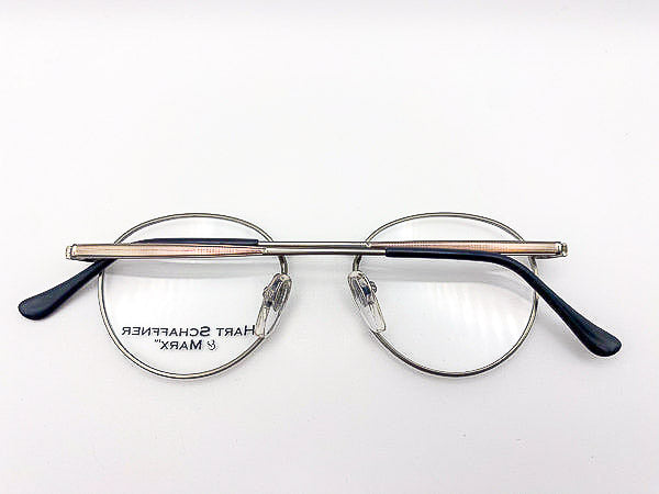 1990s round eyeglasses with a silver frame and black arms on a white background