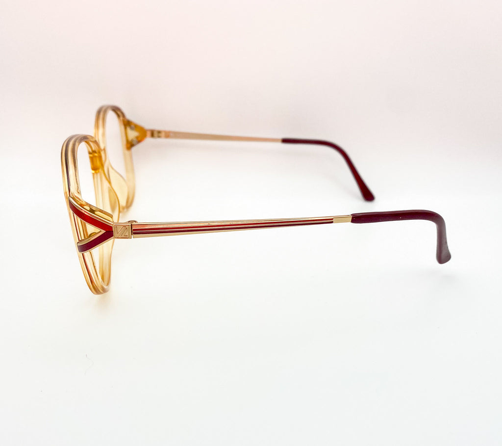 Eyeglasses with gold and red frames on a white background