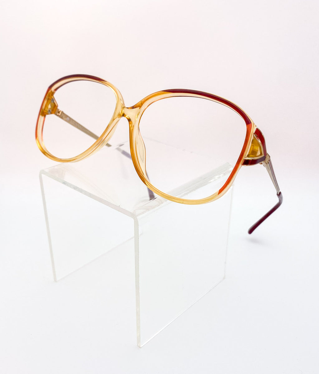 Vintage-style eyeglasses with a gradient orange and red frame on a white background