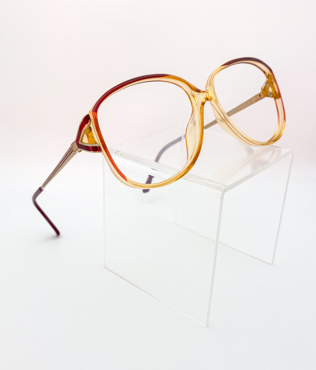 Eyeglasses with a gradient brown and gold frame on a white background