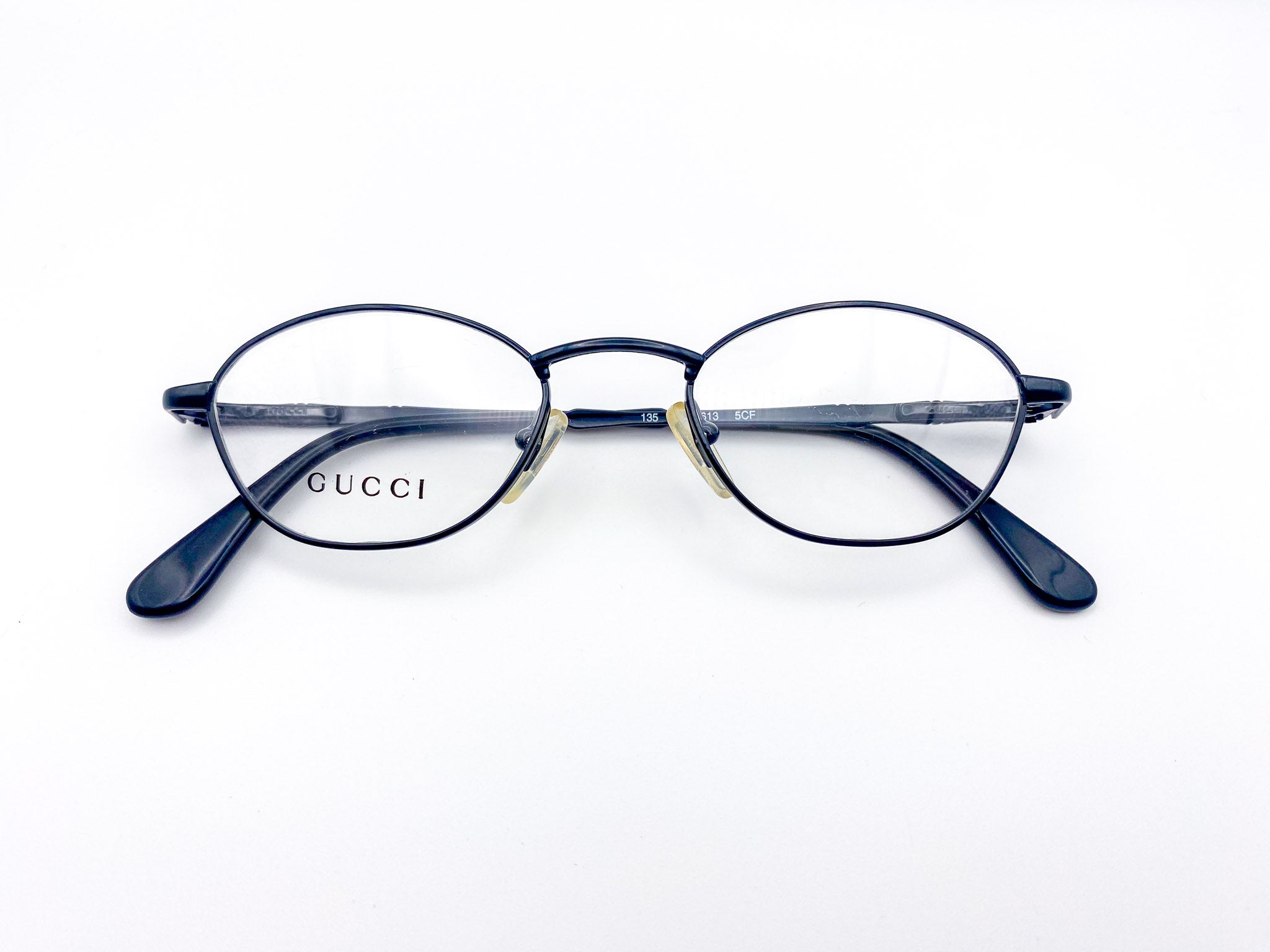 Vintage Gucci black metal eyeglasses on a white background